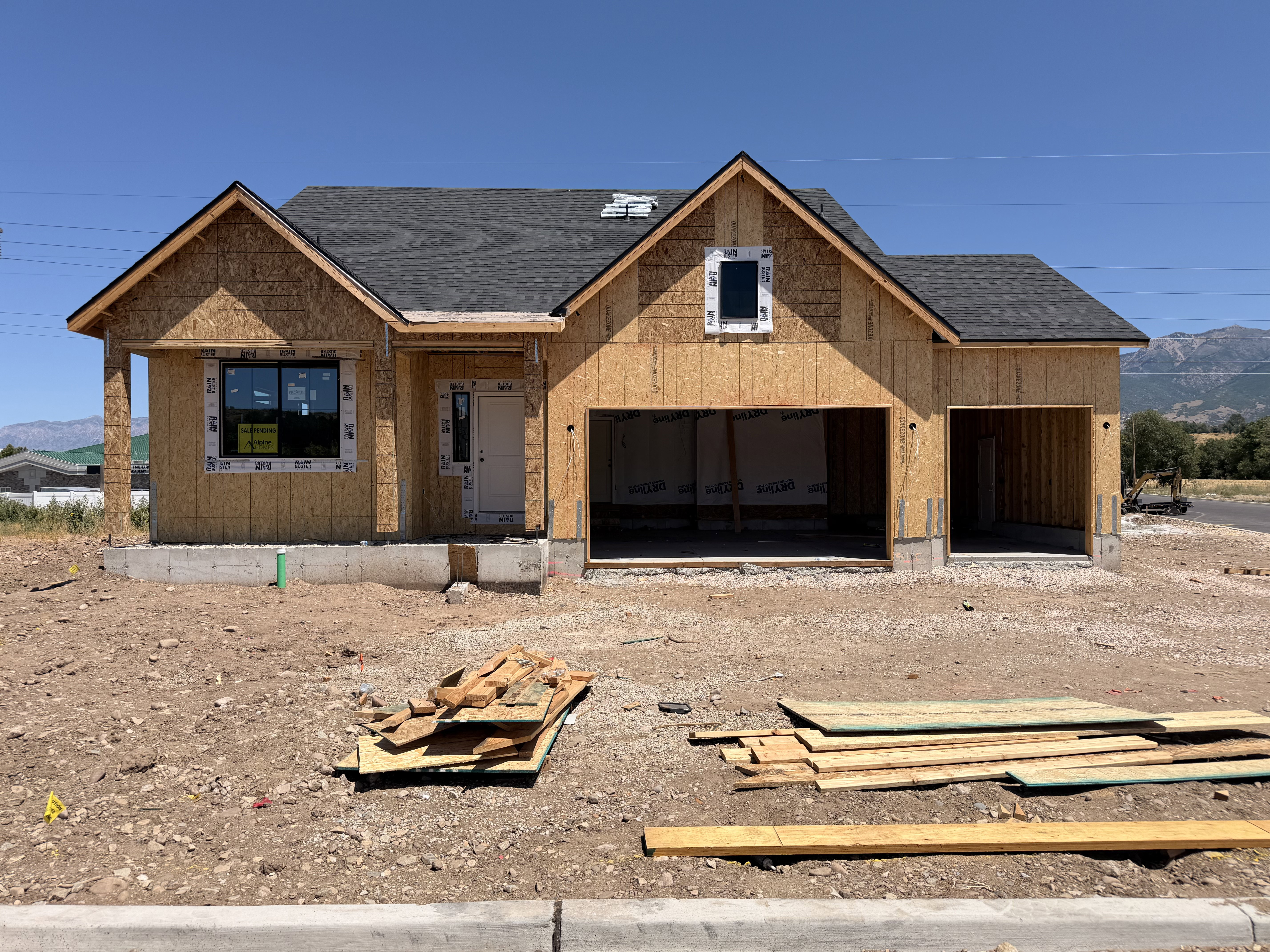New construction residence featuring a prominent two-car garage with framed openings