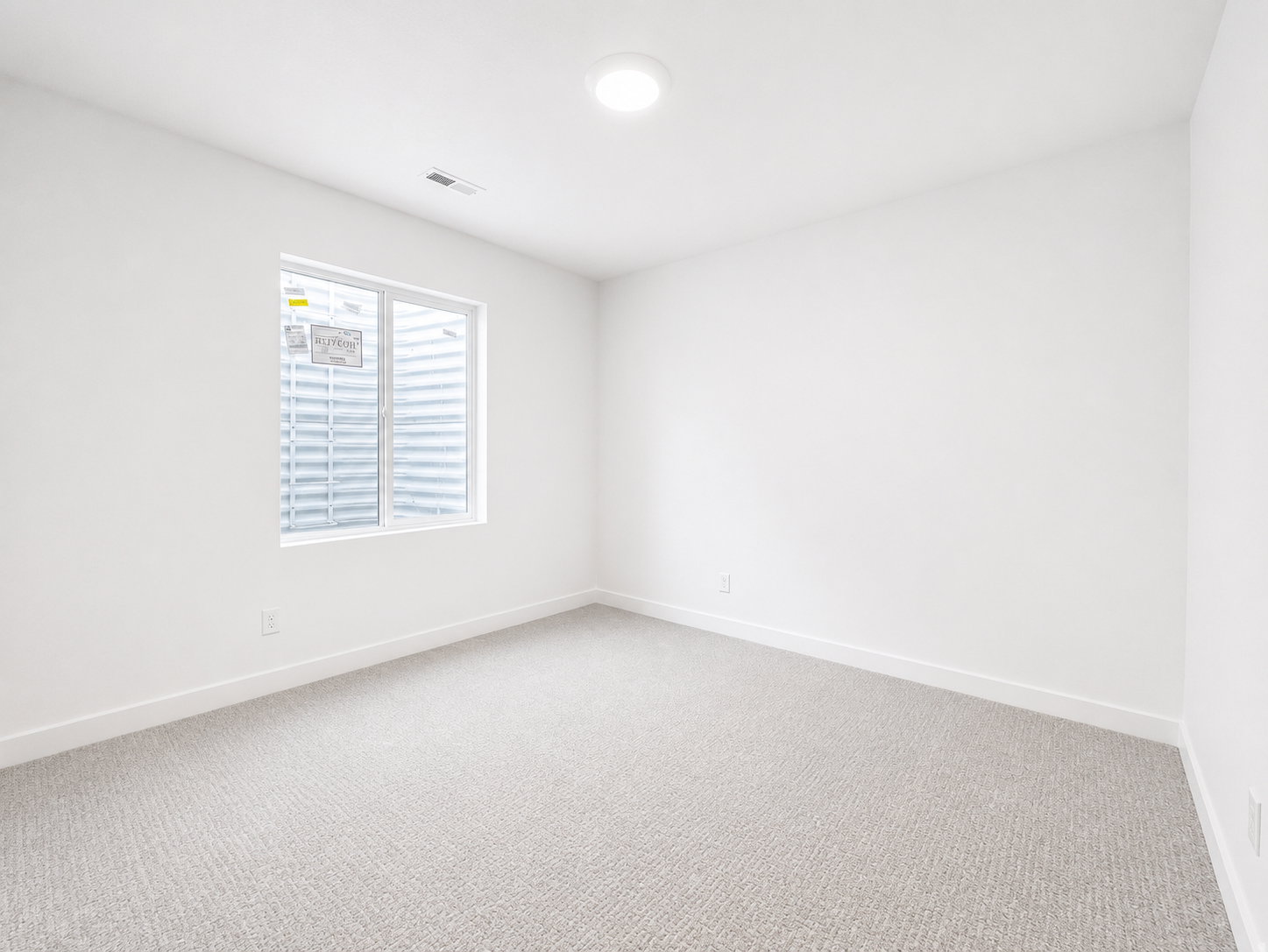 Basement bedroom featuring light gray carpeting, white walls, and white baseboards
