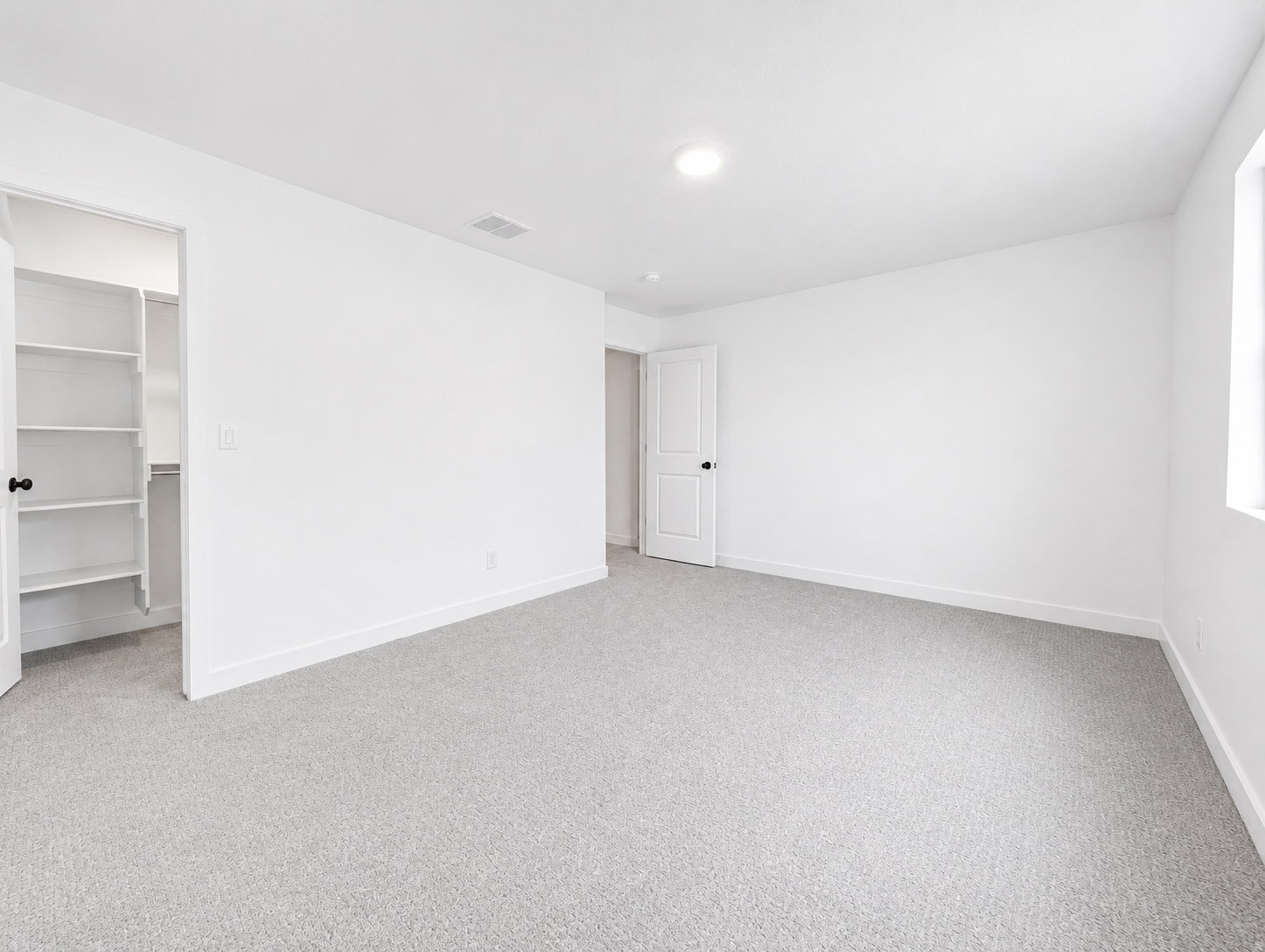 Upstairs bedroom featuring a walk-in closet with shelving, a recessed ceiling light, and natural light from a window
