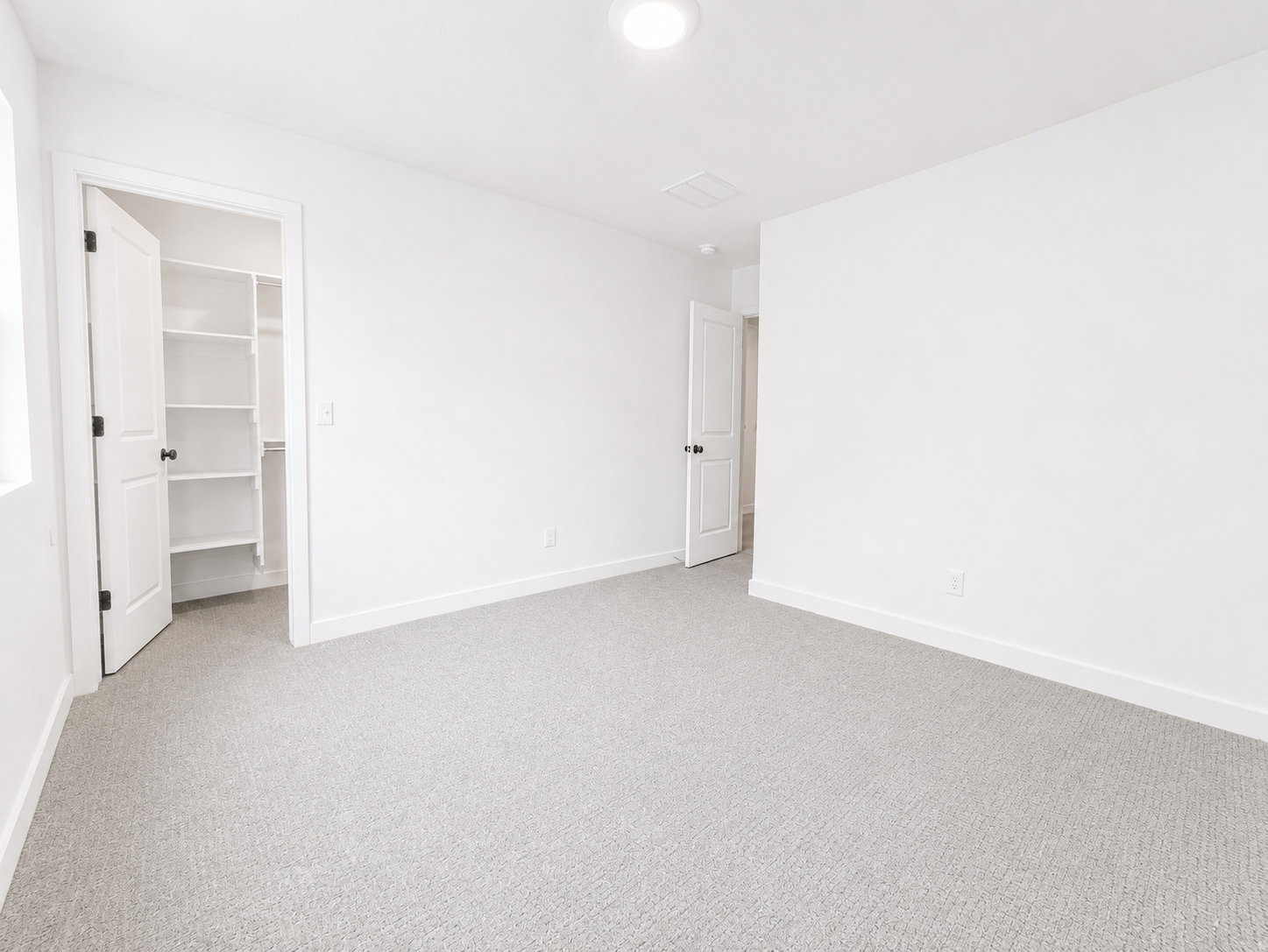 Upstairs bedroom featuring a walk-in closet with shelving, a recessed ceiling light, and natural light from a window