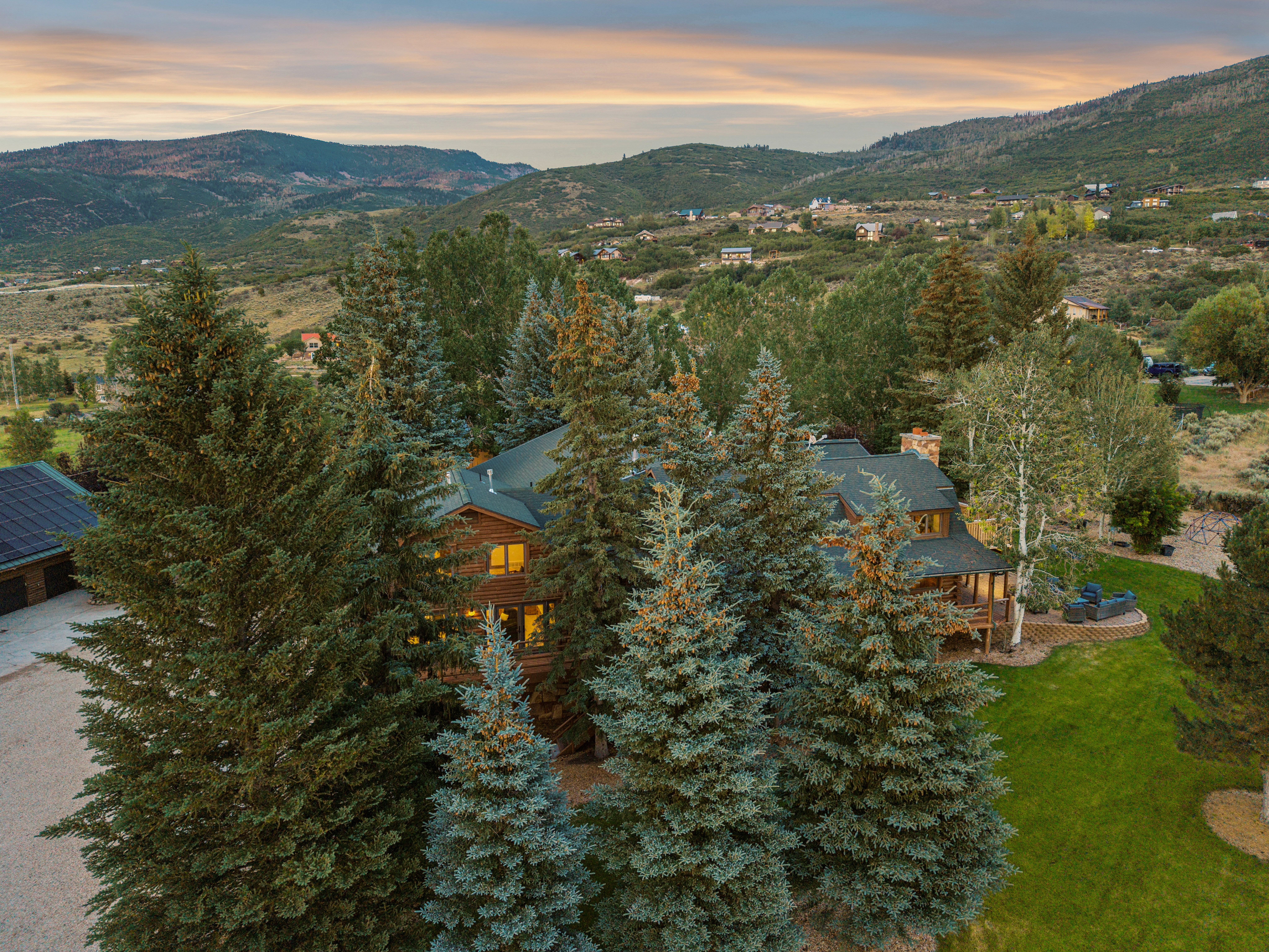 Wood-sided residence surrounded by mature evergreen trees