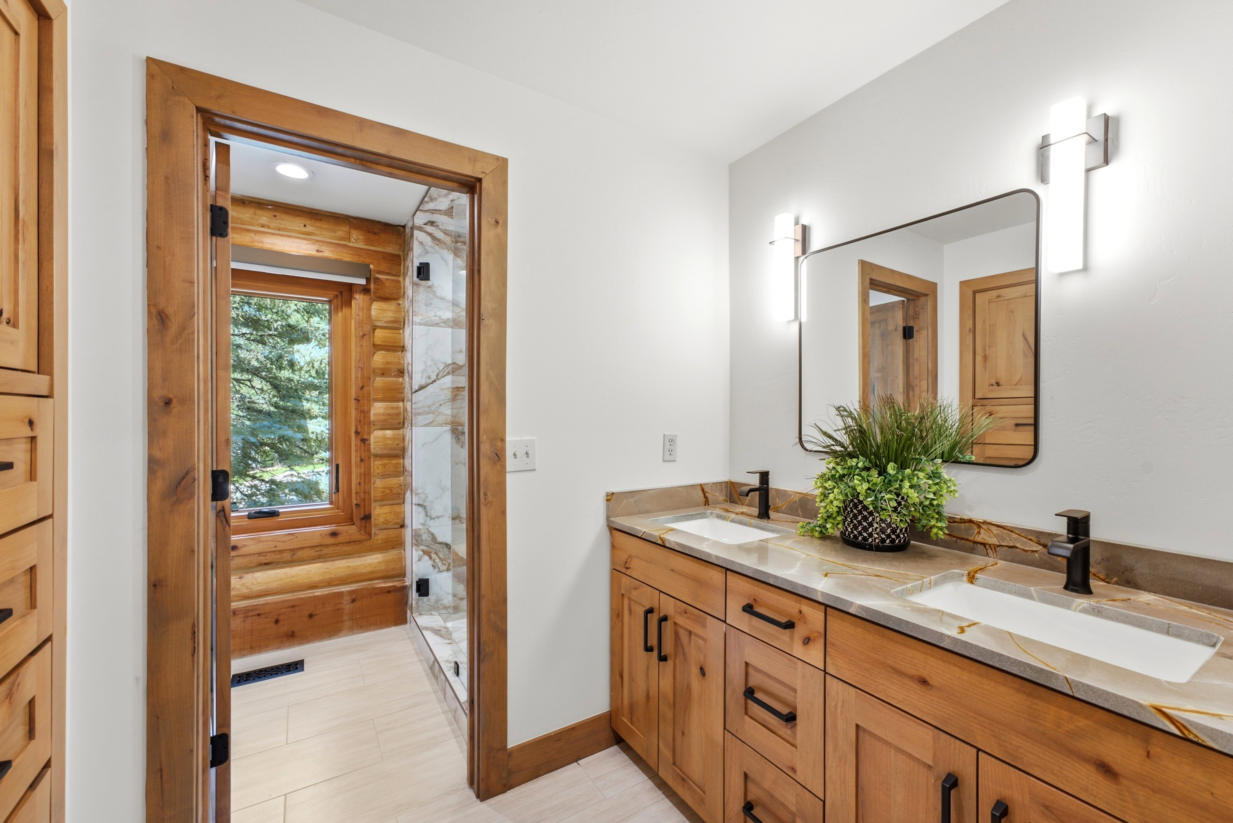Dual vanity with custom wood cabinetry, stone countertops, and rectangular sinks