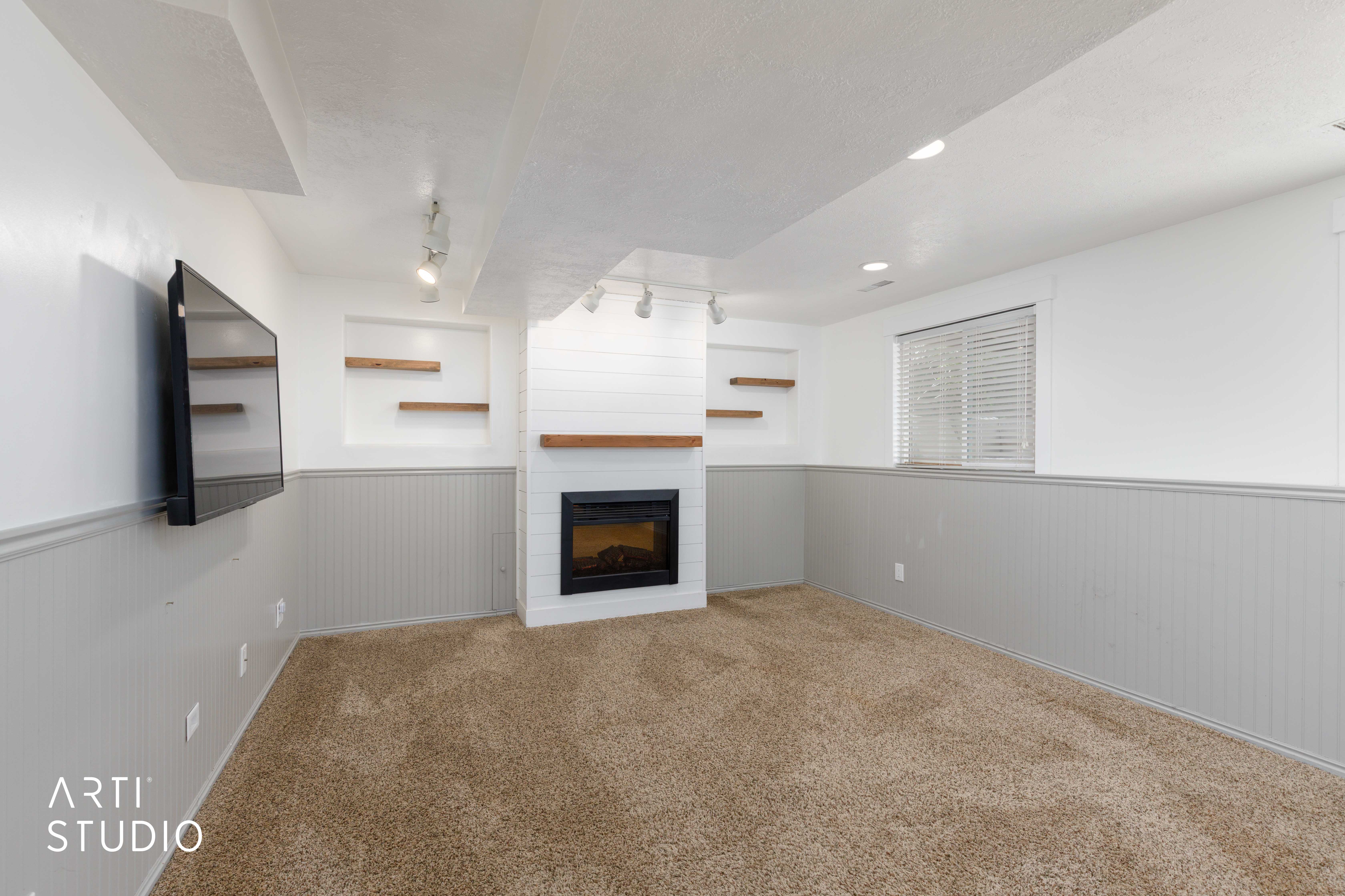 Living area featuring a fireplace with shiplap surround, wood mantel, and integrated shelving
