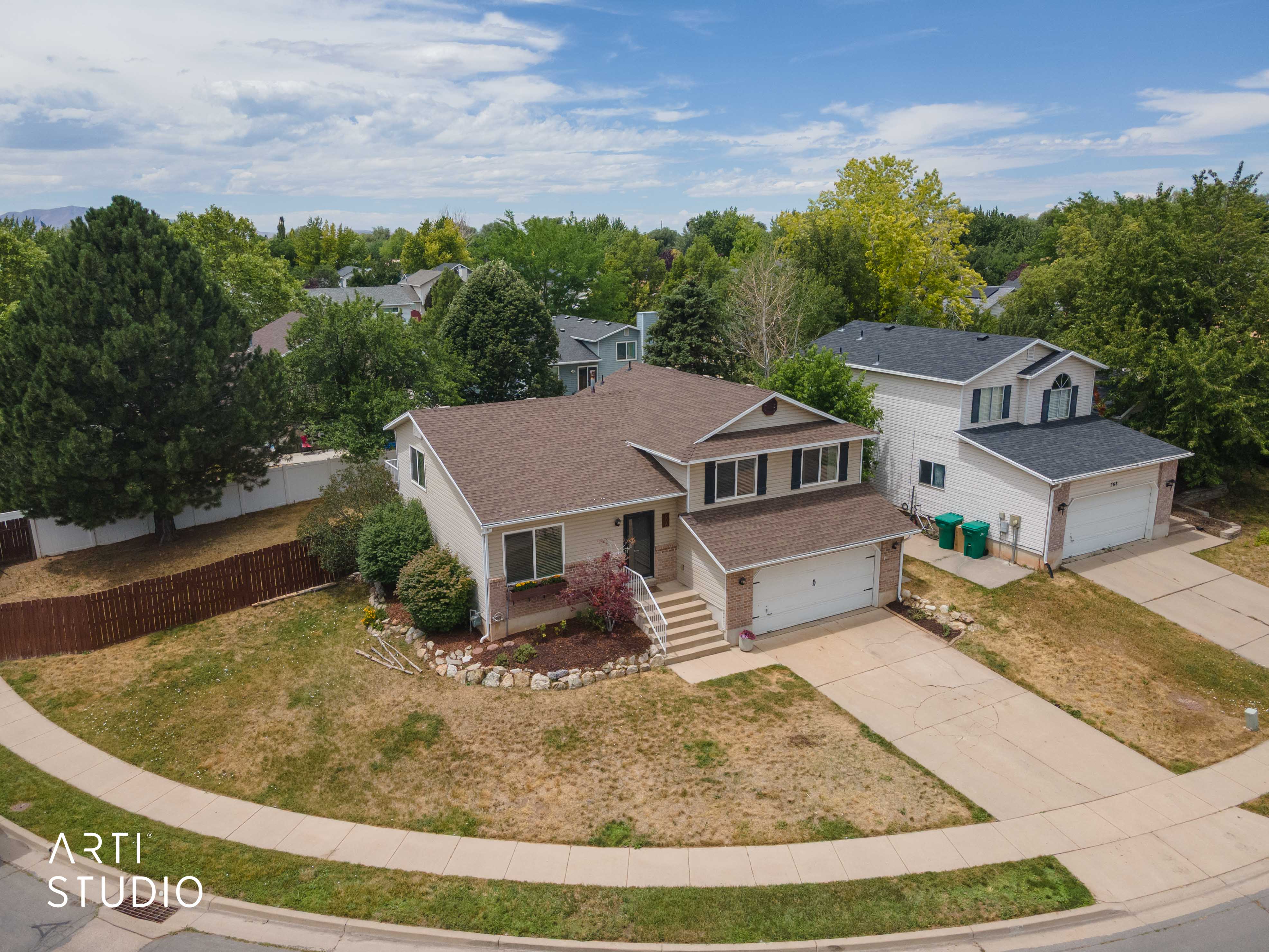 Two-story residence featuring a two-car garage, brick accents, and a covered front entry