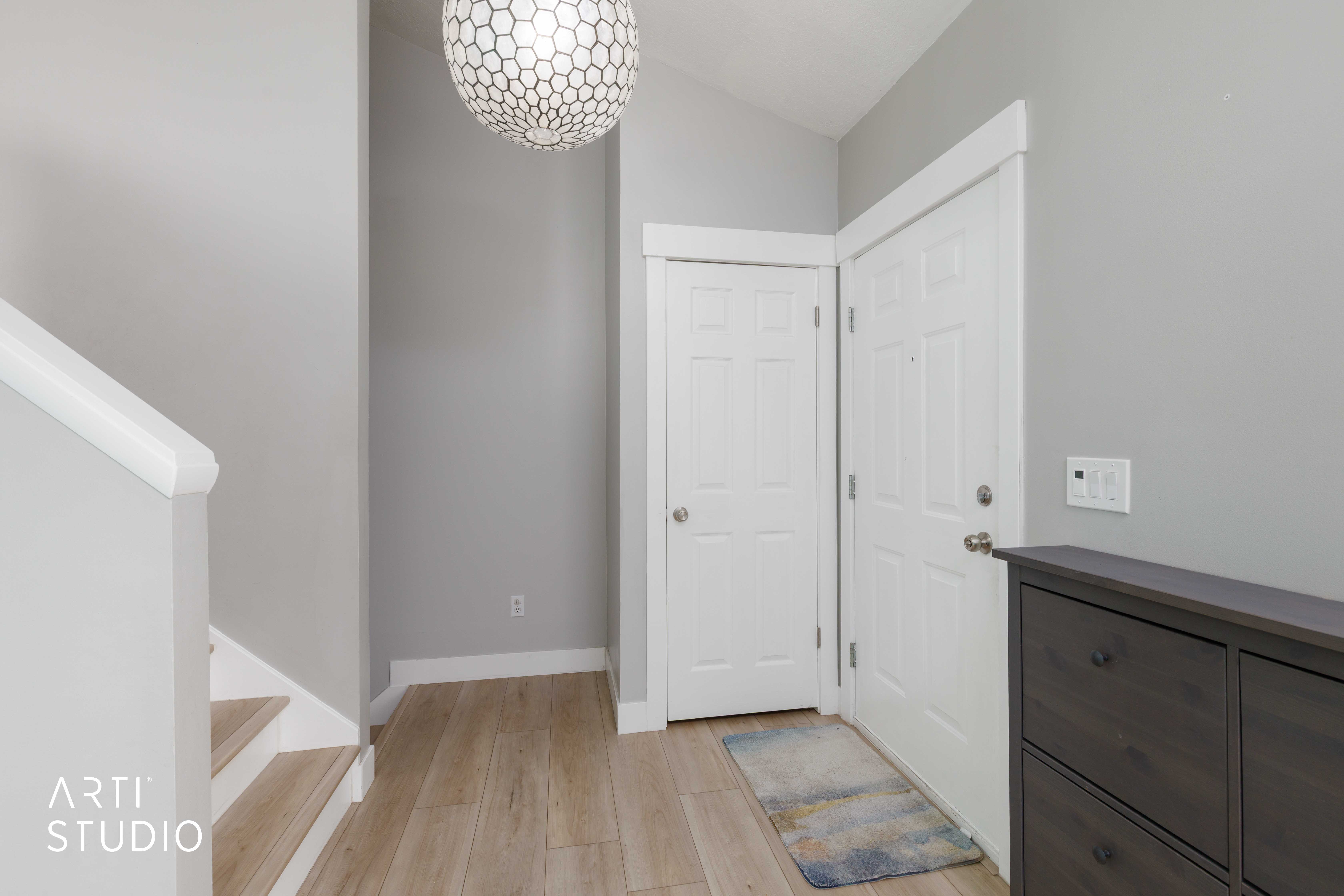 Entryway featuring light wood-finish flooring, light grey walls, and white trim