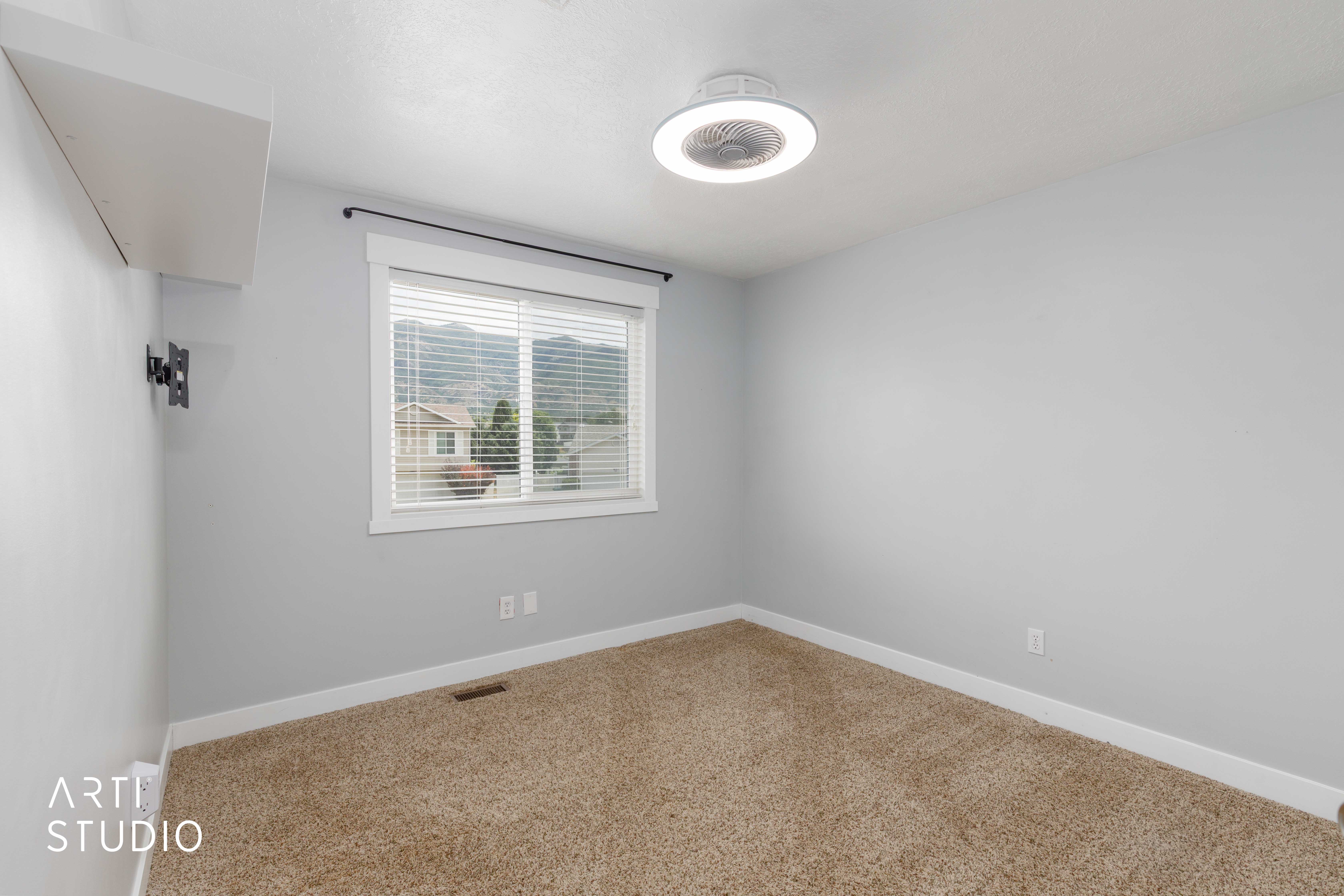 Room featuring light gray walls, plush carpet flooring, and a window with white blinds and trim