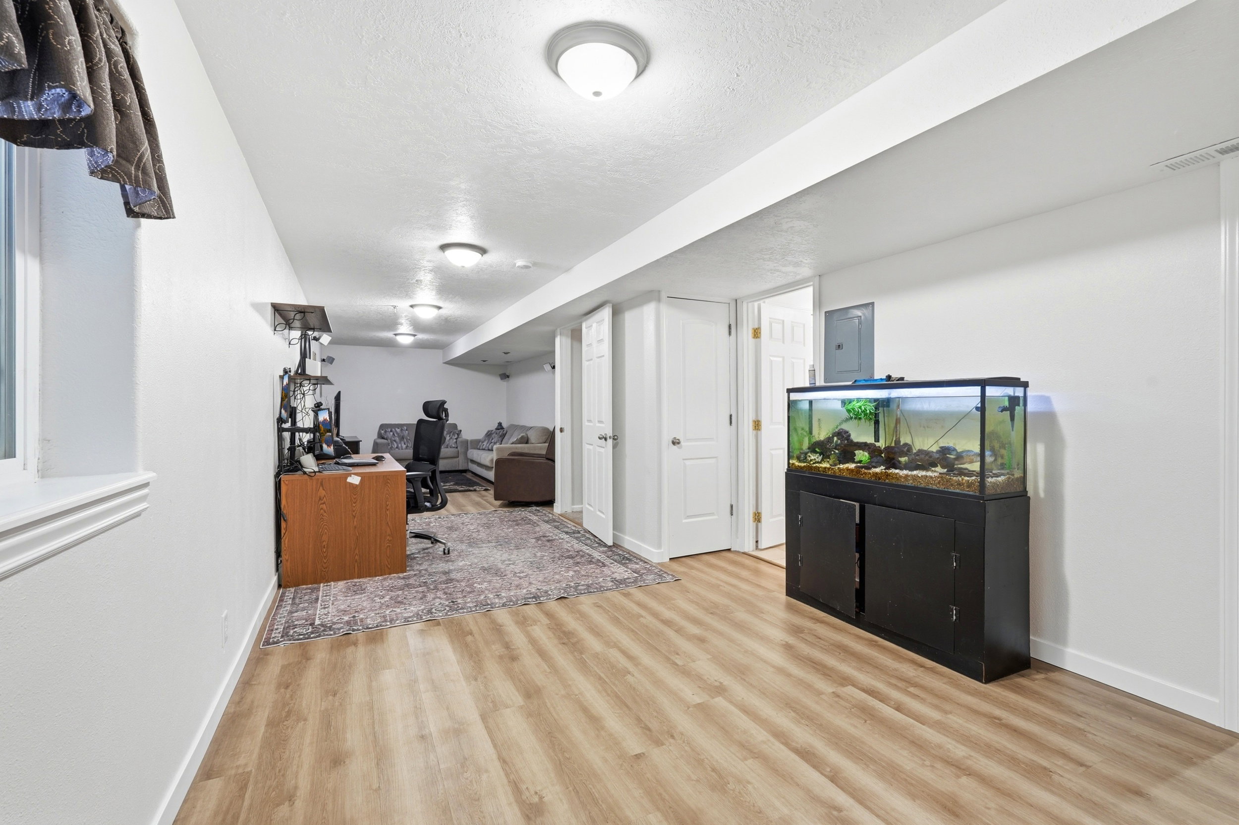 Finished lower level featuring wood-finish flooring, recessed lighting, and bright white walls