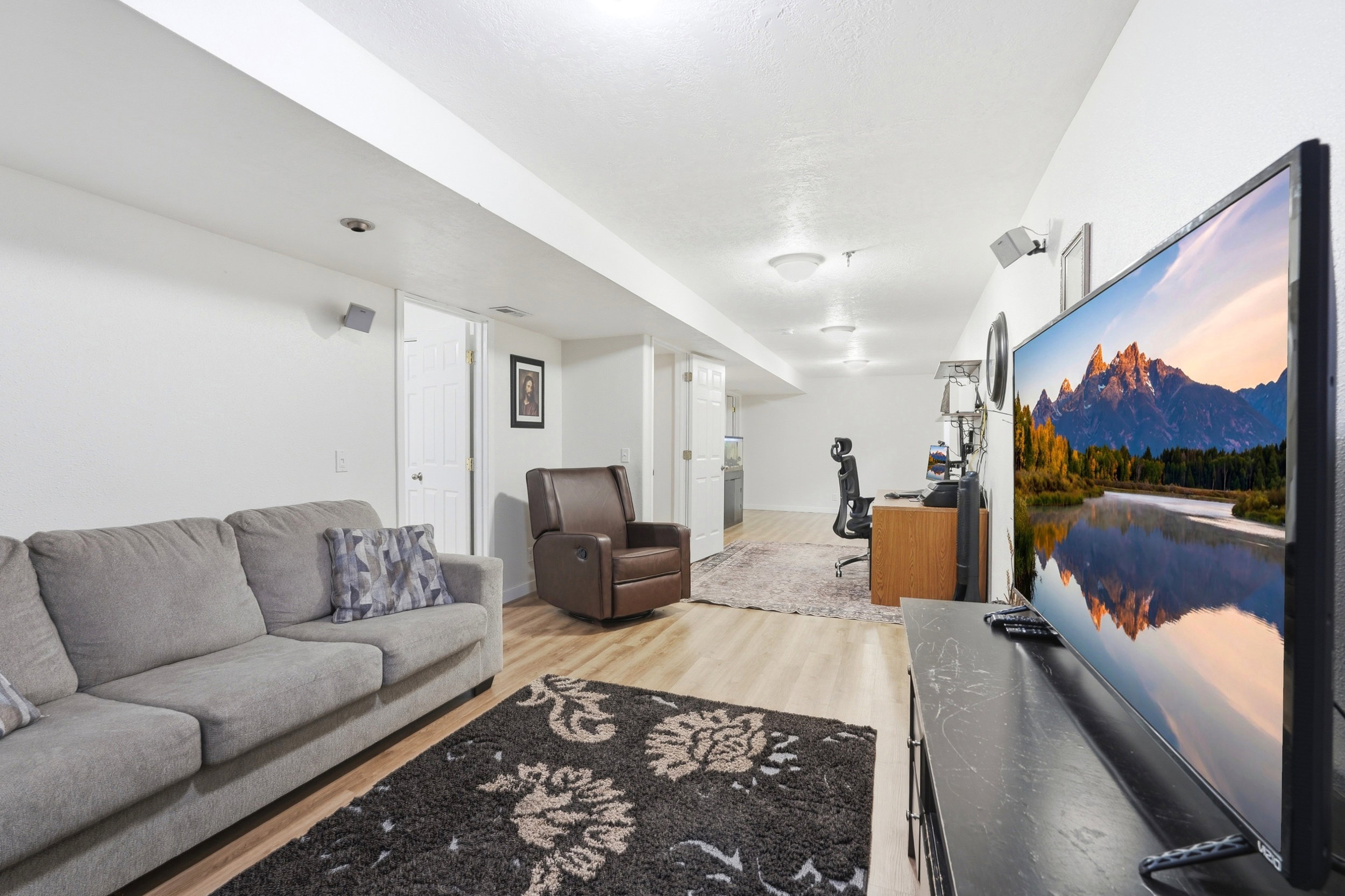 Open-concept living area featuring wood-finish flooring, recessed lighting, and white walls