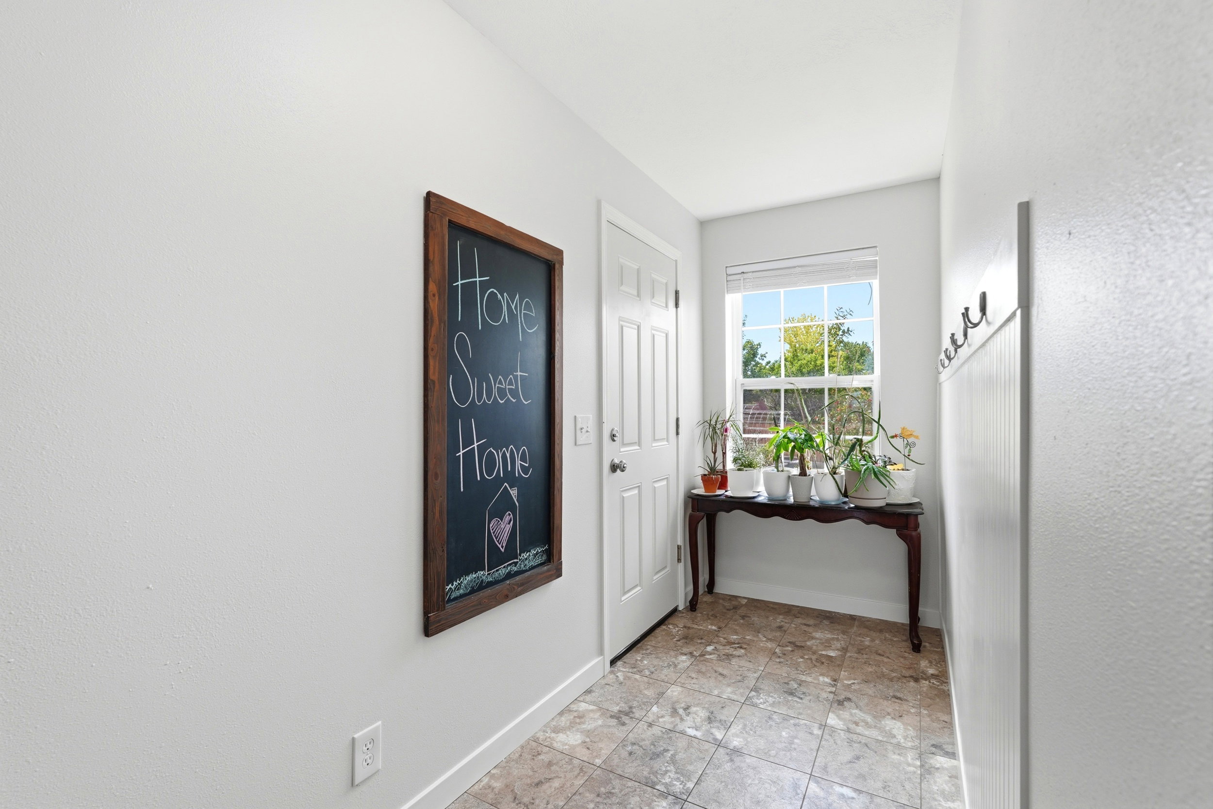 Entryway featuring tiled flooring, a white paneled door, and a window with natural light