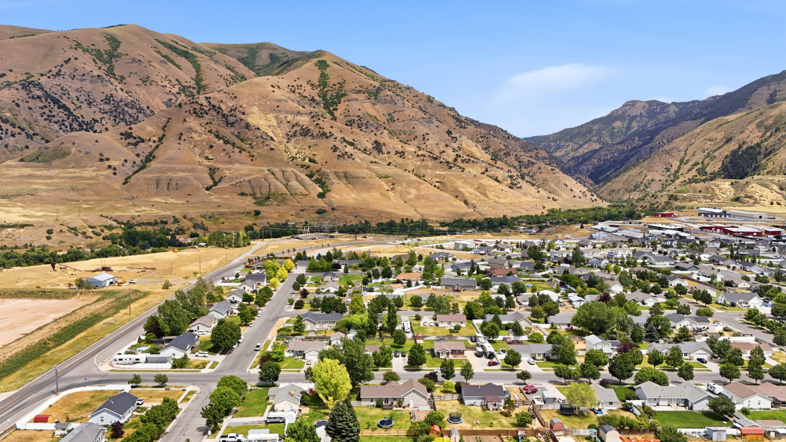 Expansive aerial view showcasing a residential community nestled at the base of arid mountains