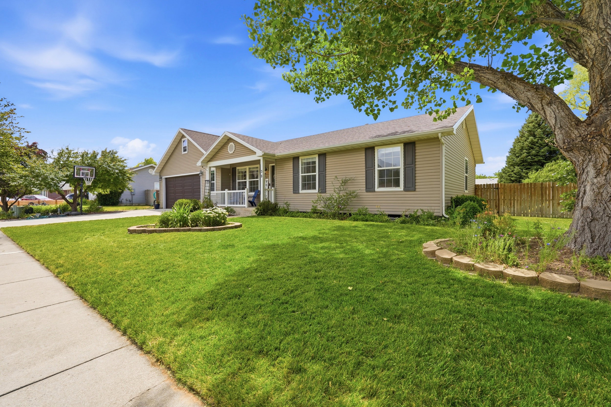 Ranch-style exterior with tan siding and dark shutters