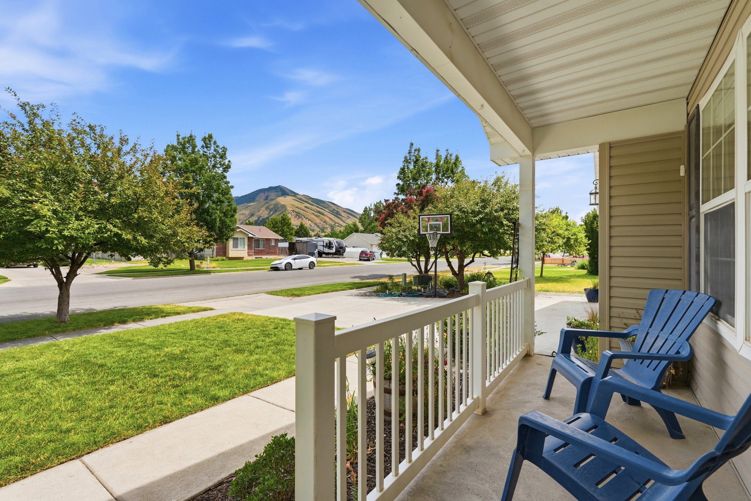 Covered porch with white railings and beige siding