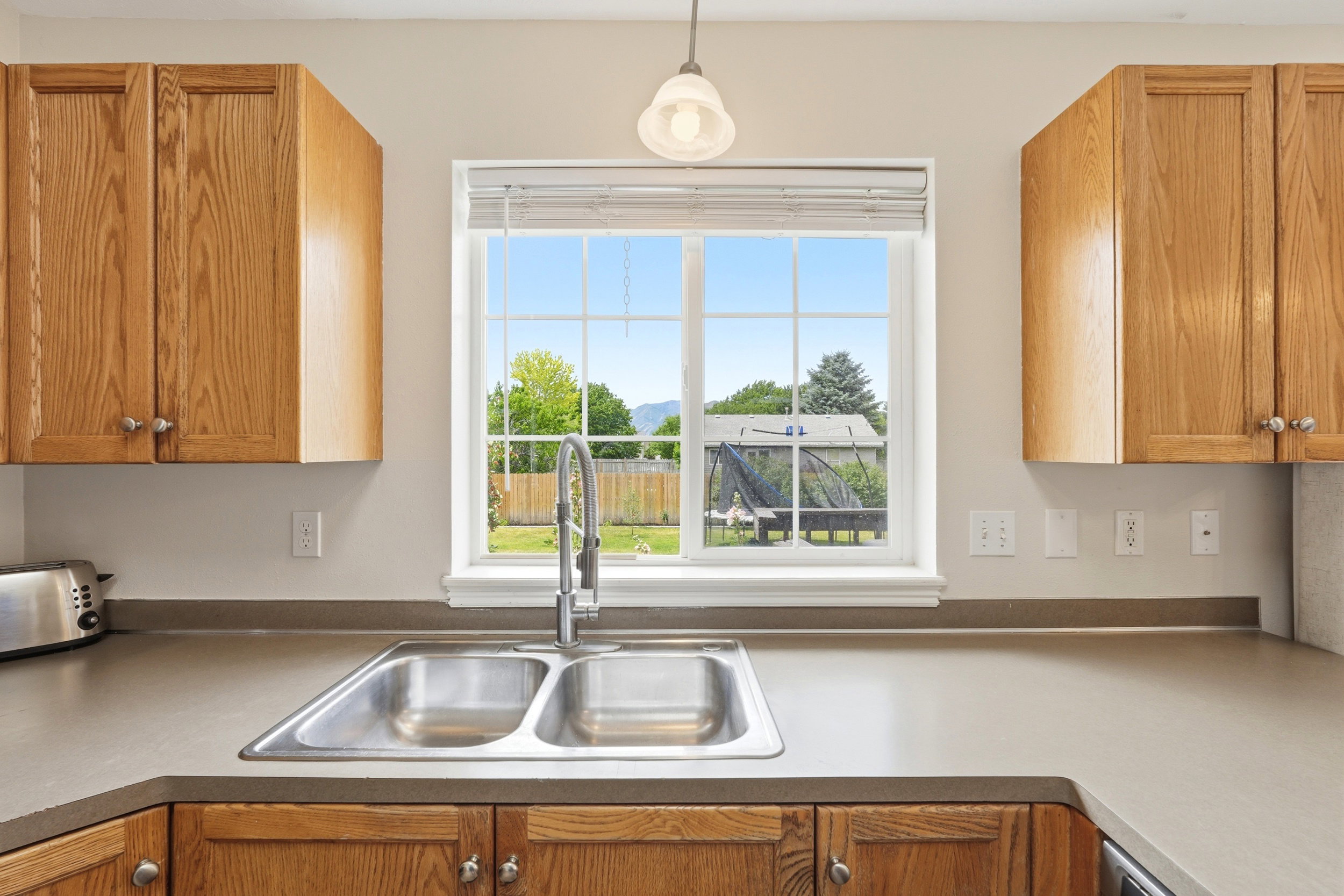 Kitchen sink with dual basins and a gooseneck faucet