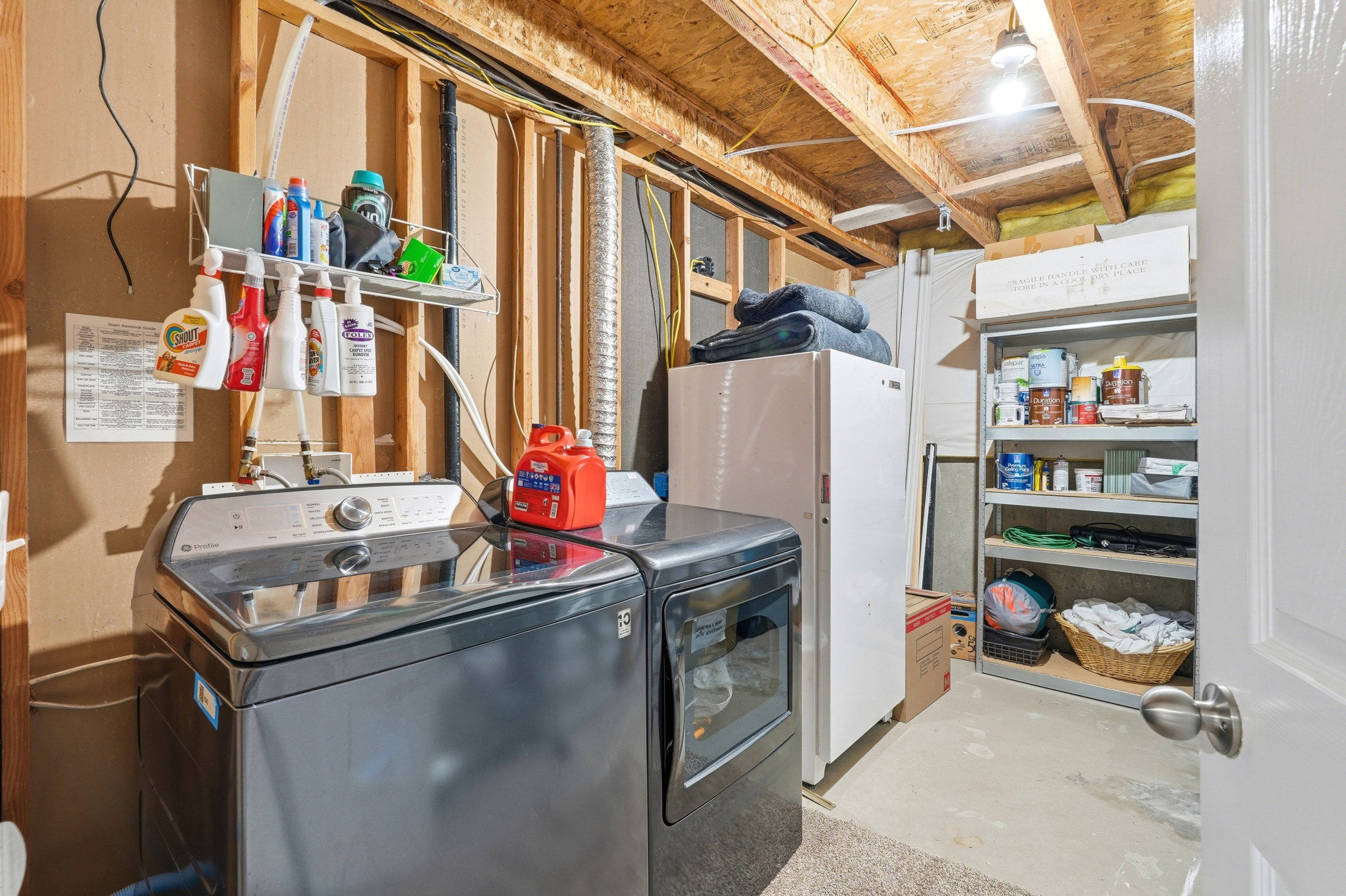 Utility area with concrete flooring, exposed ceiling joists, and open wall studs