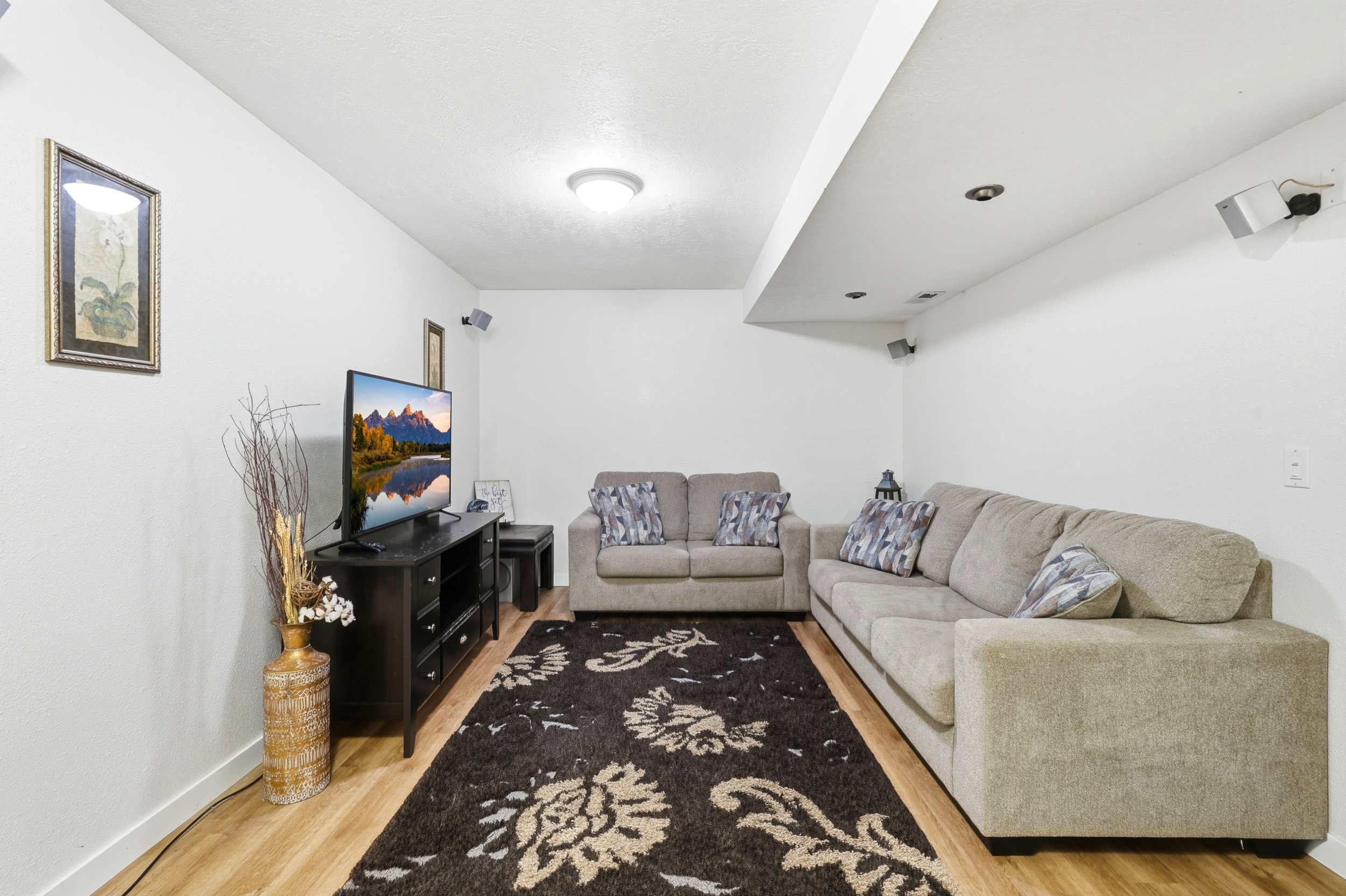 Recessed lighting and ceiling-mounted speakers complement the wood-finish flooring