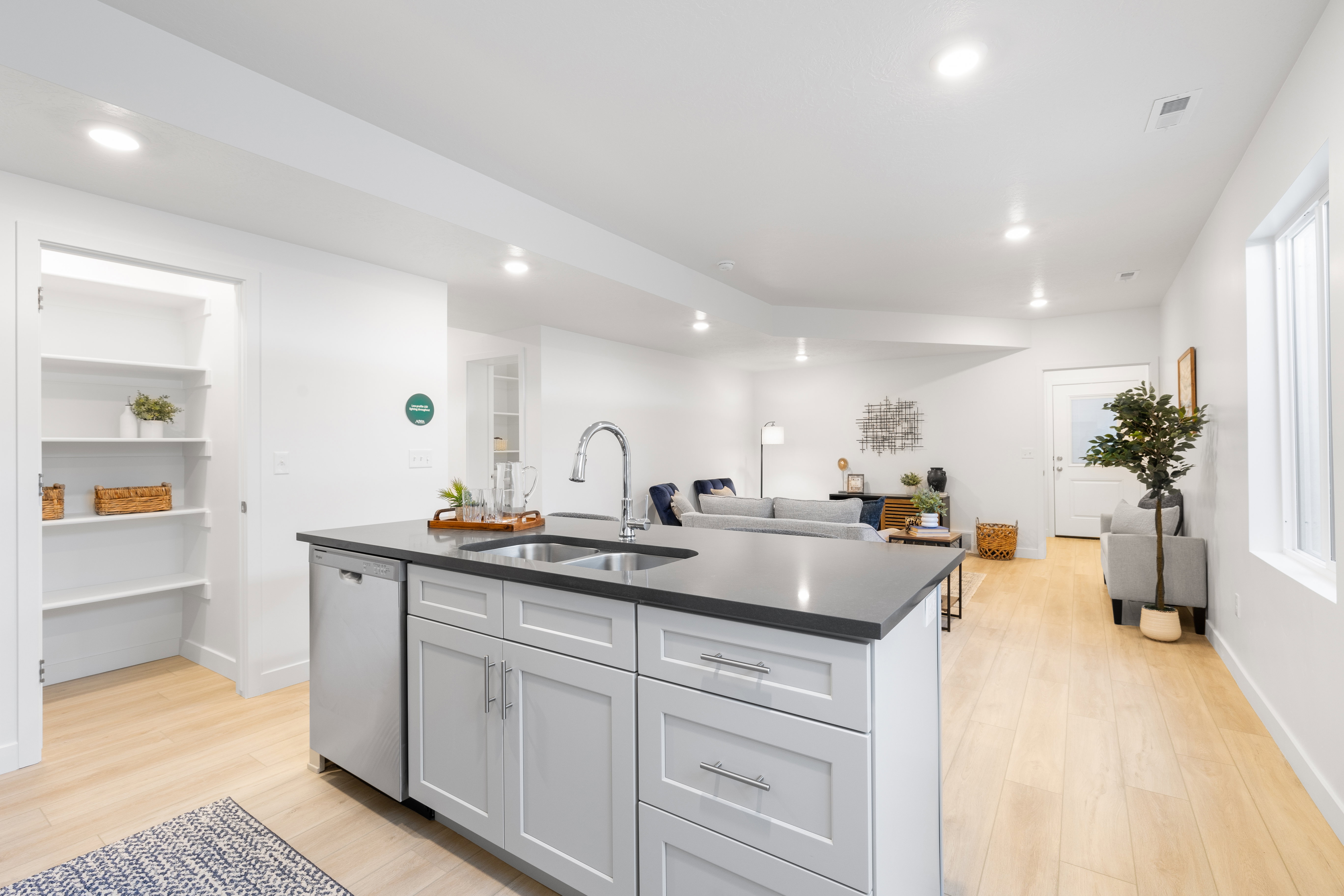 Kitchen island featuring a double-basin stainless steel sink, pull-down faucet, and integrated dishwasher