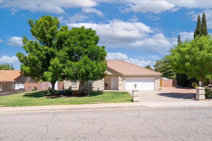 Single-story residence featuring a two-car garage, concrete driveway, and a tiled roof