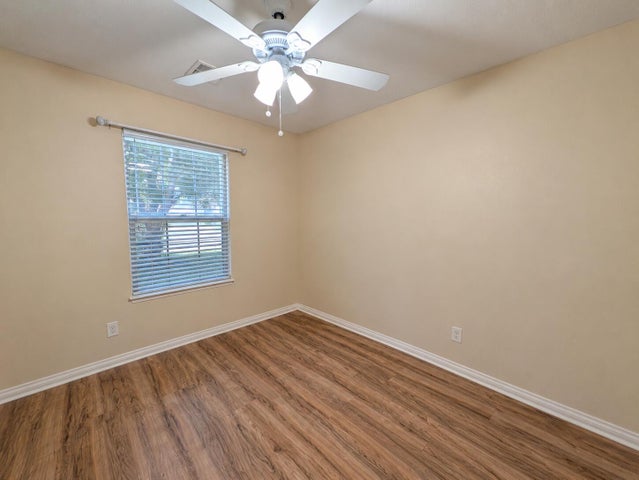 Wood-finish flooring, neutral wall tones, and crown molding define this interior space