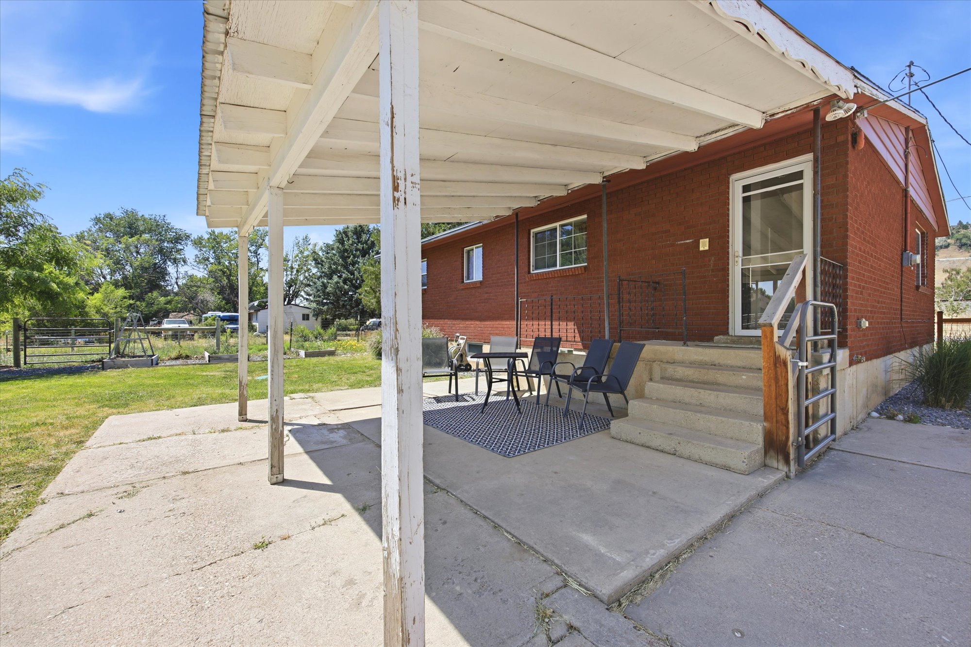 Covered patio area with concrete flooring to sit and enjoy the expansive backyard.