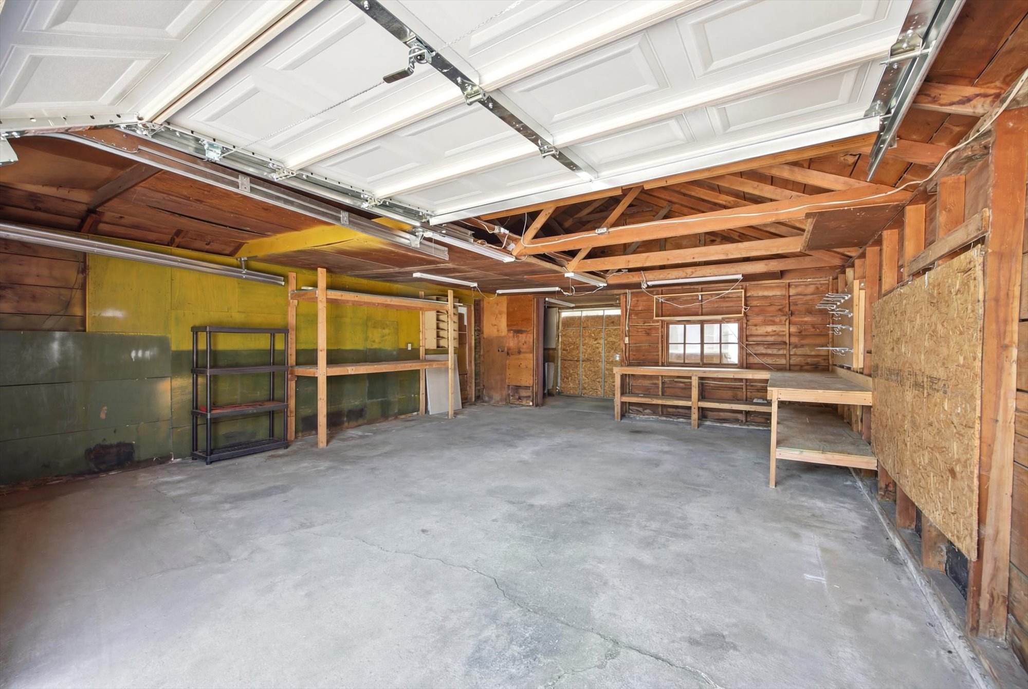 Spacious garage featuring a concrete floor and shelving