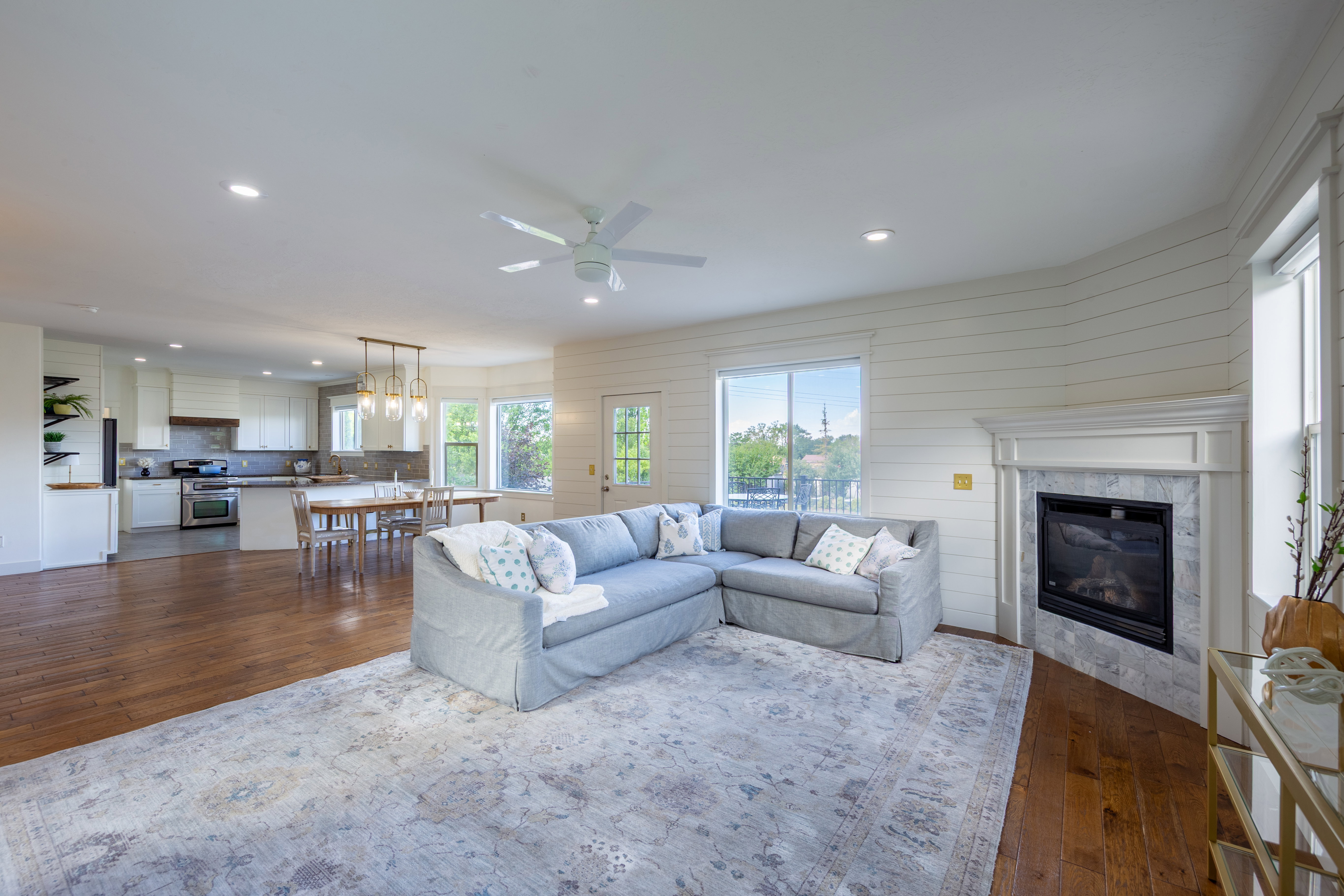 Open-concept living area featuring rich wood-finish flooring, recessed lighting, and a ceiling fan