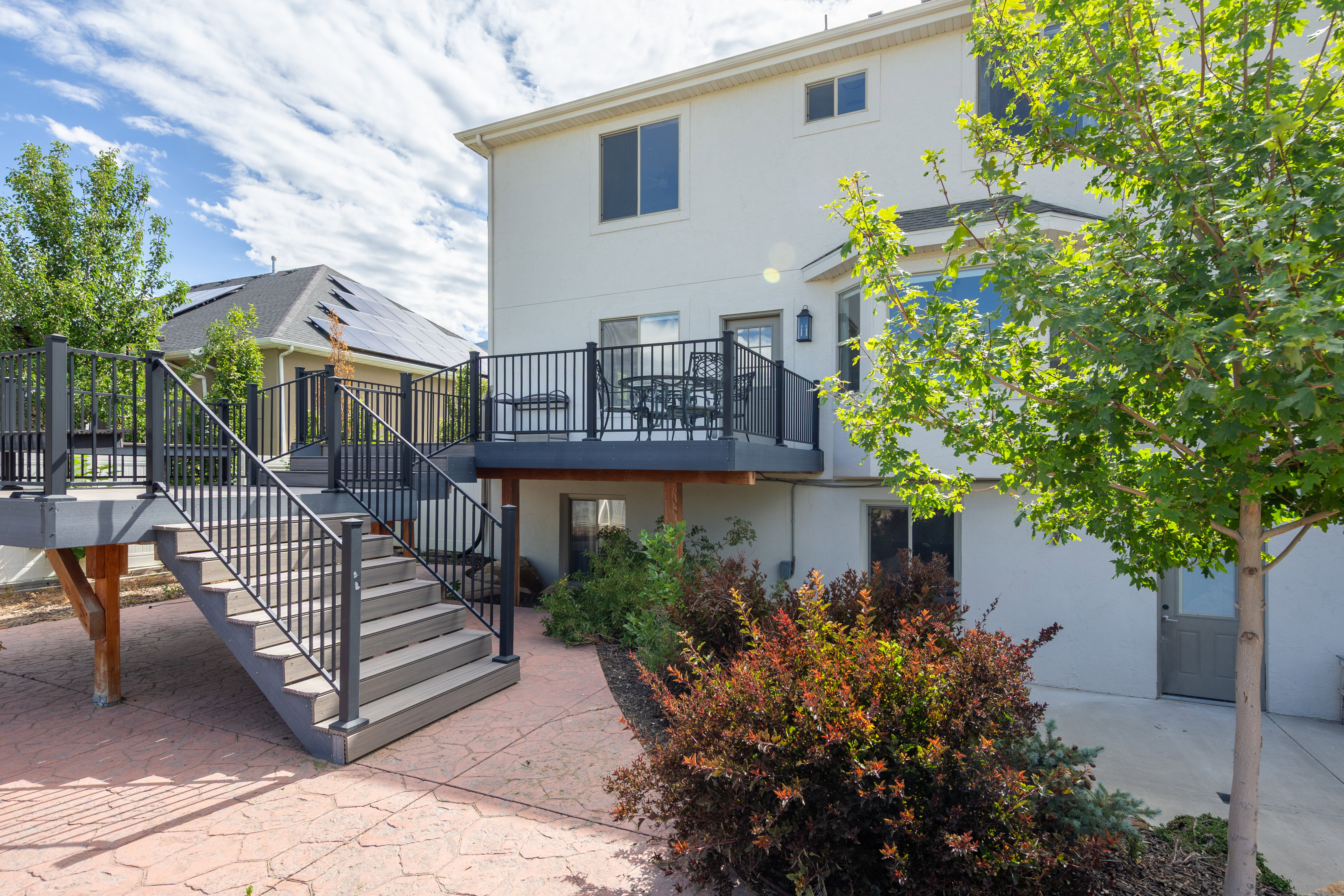 Multi-level outdoor deck featuring composite decking and black metal railings