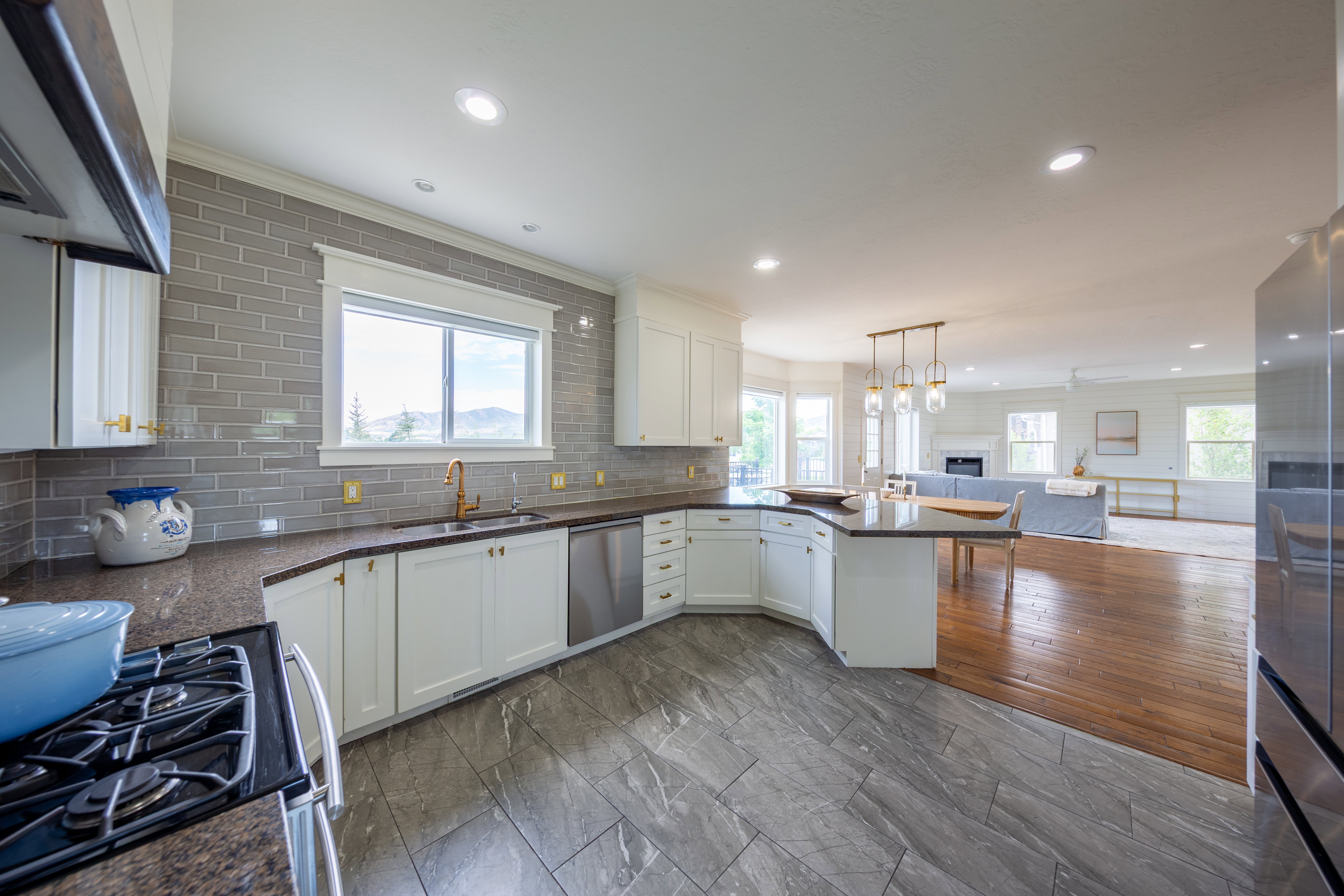 Modern kitchen featuring white cabinetry, a gray subway tile backsplash, dark countertops, and stainless steel appliances