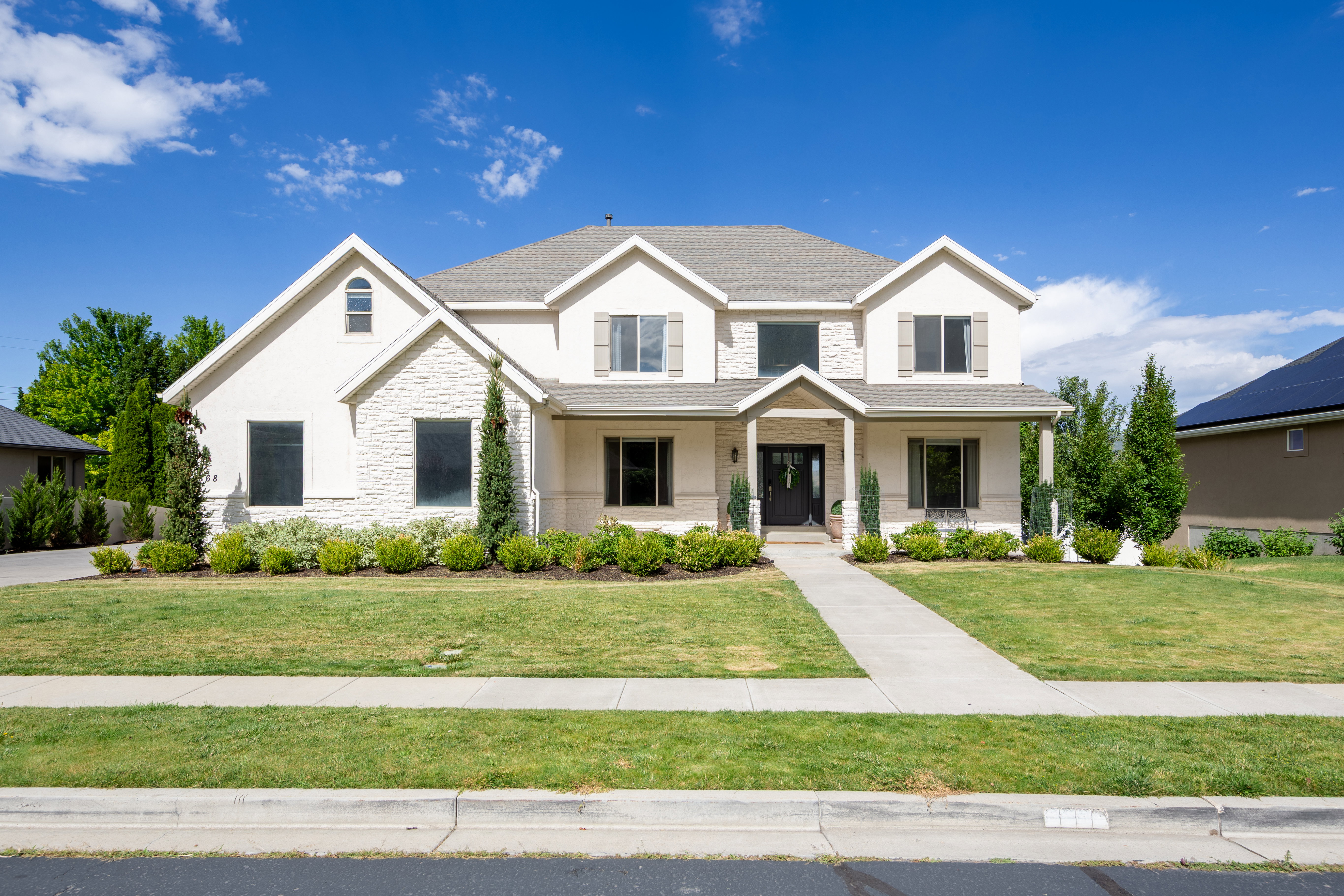 Stately two-story residence featuring a combination of stucco and stone veneer siding