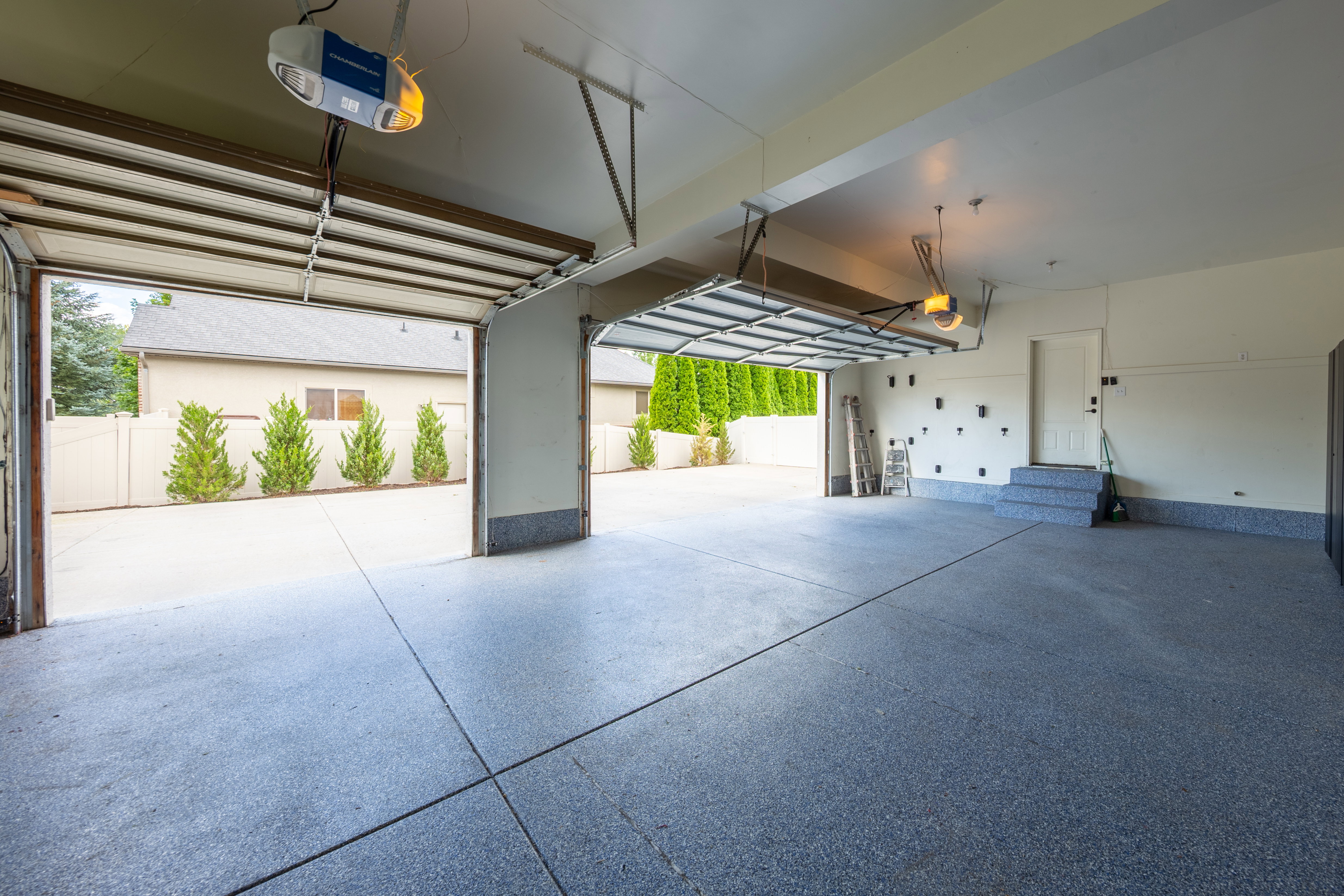 Spacious garage featuring a durable epoxy floor coating, two automatic garage door openers, and direct entry to the interior