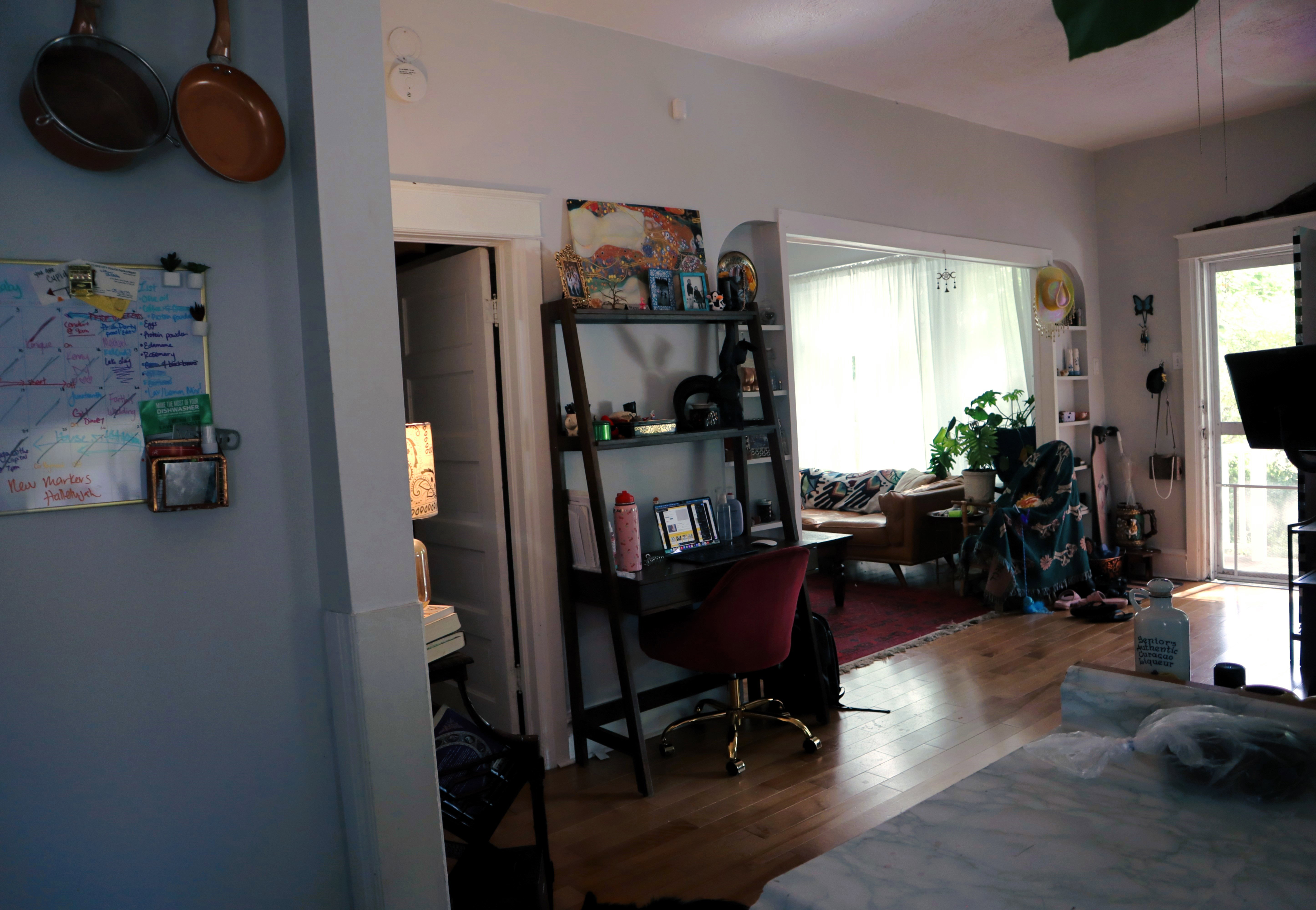 Open floor plan featuring wood-finish flooring, light grey walls, and a large arched entryway