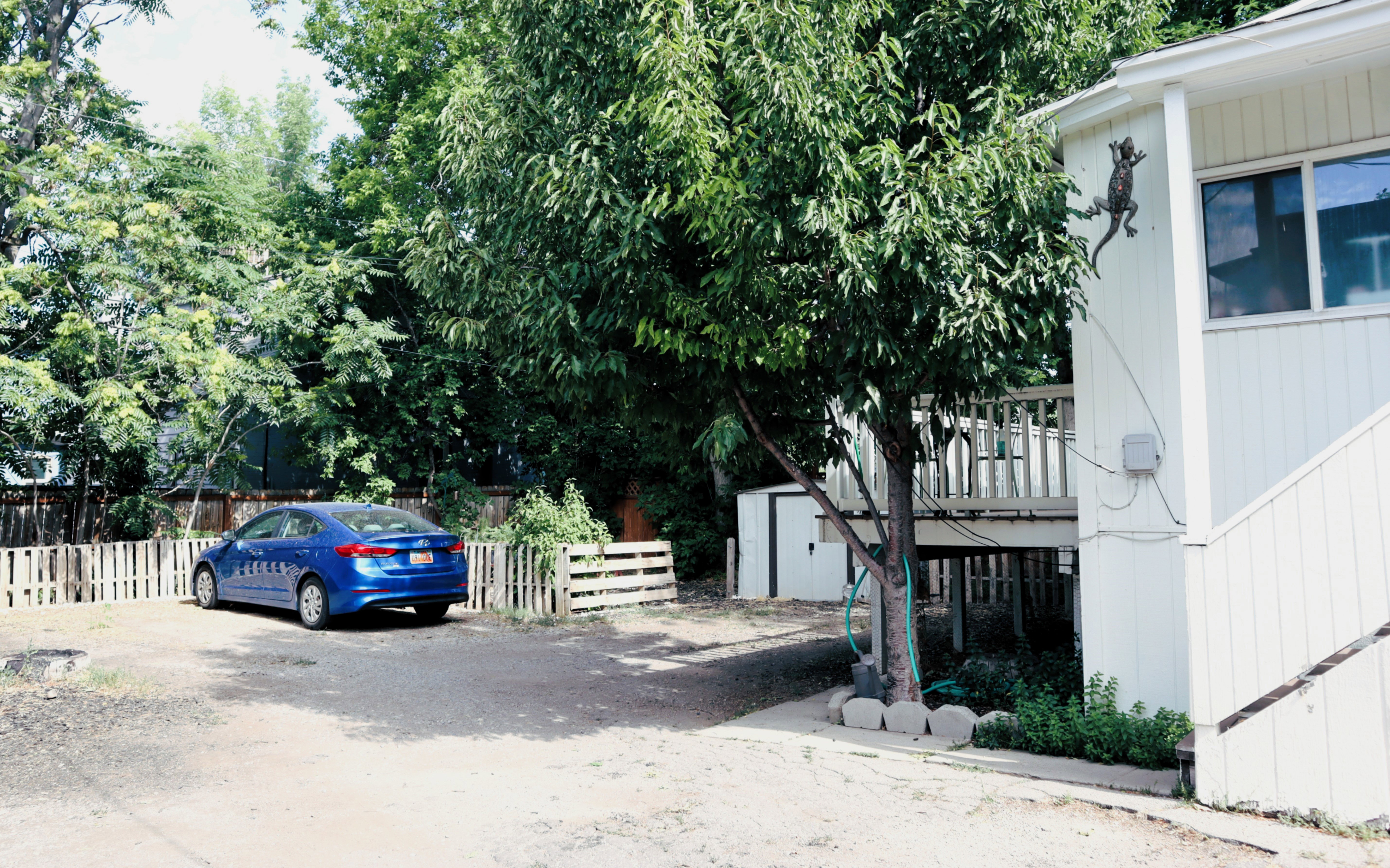 Exterior features include a multi-level deck, white siding, and an outdoor storage shed