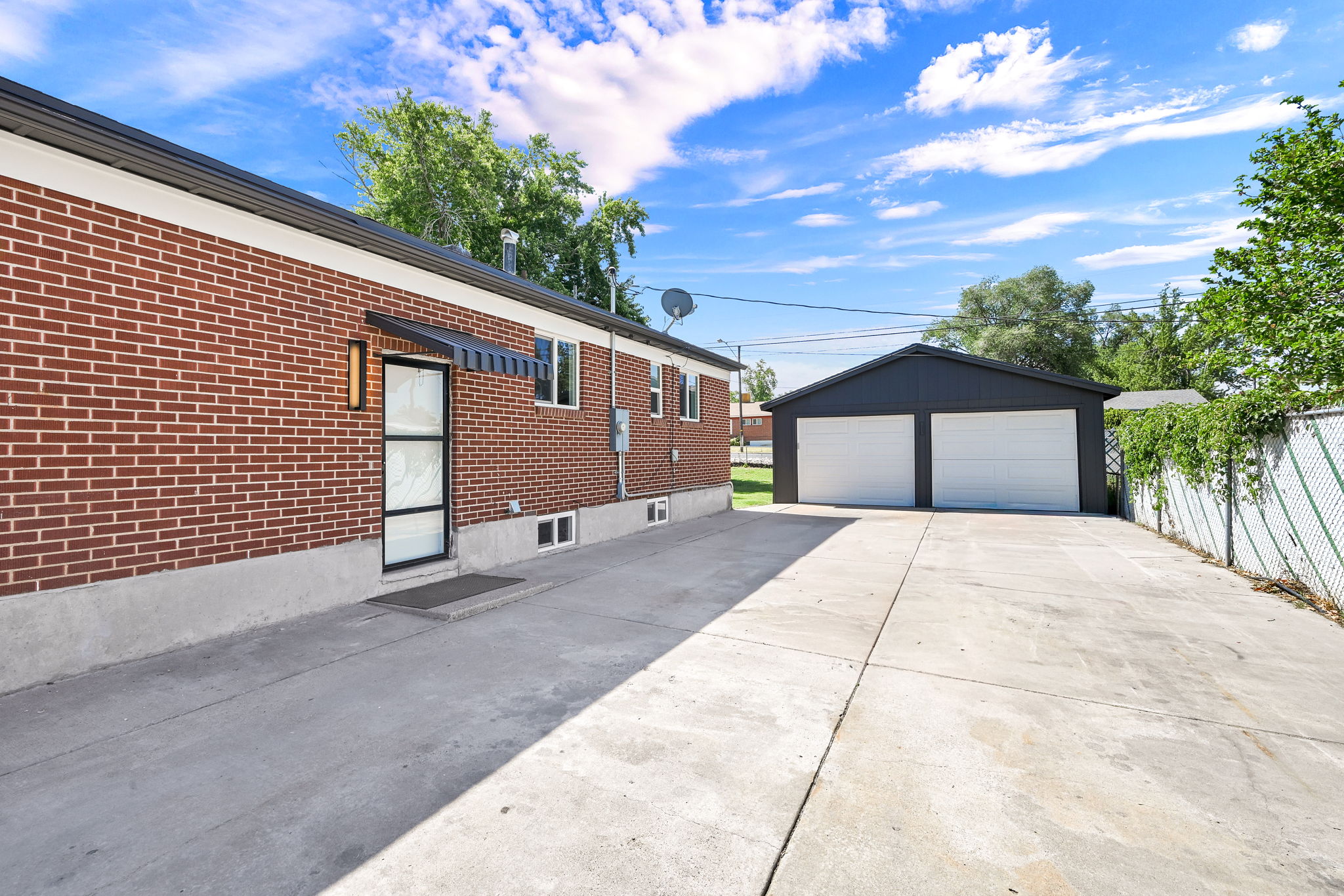 Brick exterior with a modern black entry door and awning