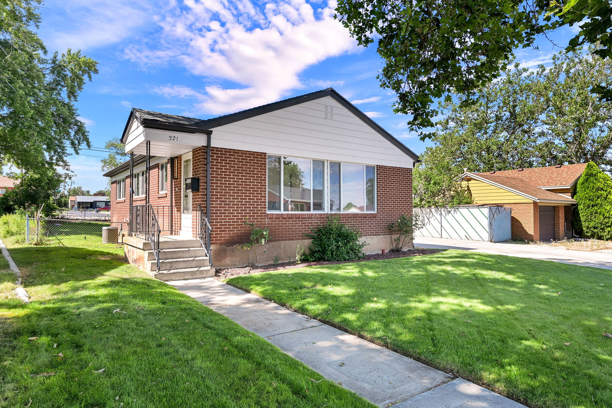 Brick exterior with a covered front porch featuring wrought iron railings