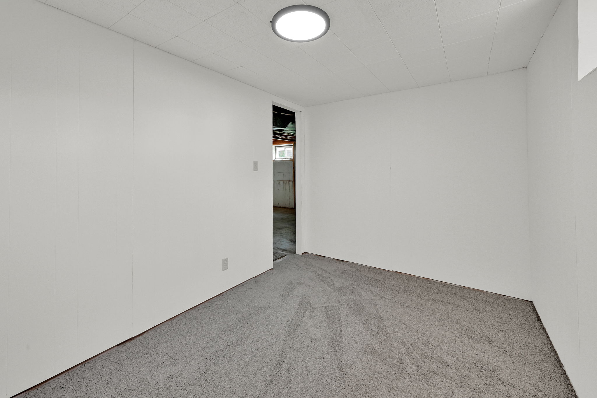 Carpeted room with white panel walls and a drop ceiling
