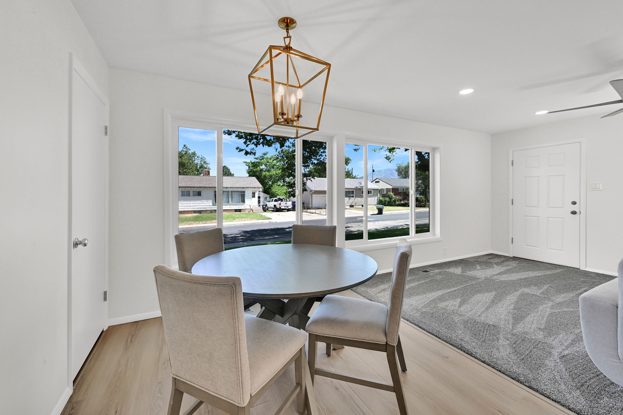 Dining area featuring a prominent window, a gold-finish geometric chandelier, recessed lighting, and wood-finish flooring
