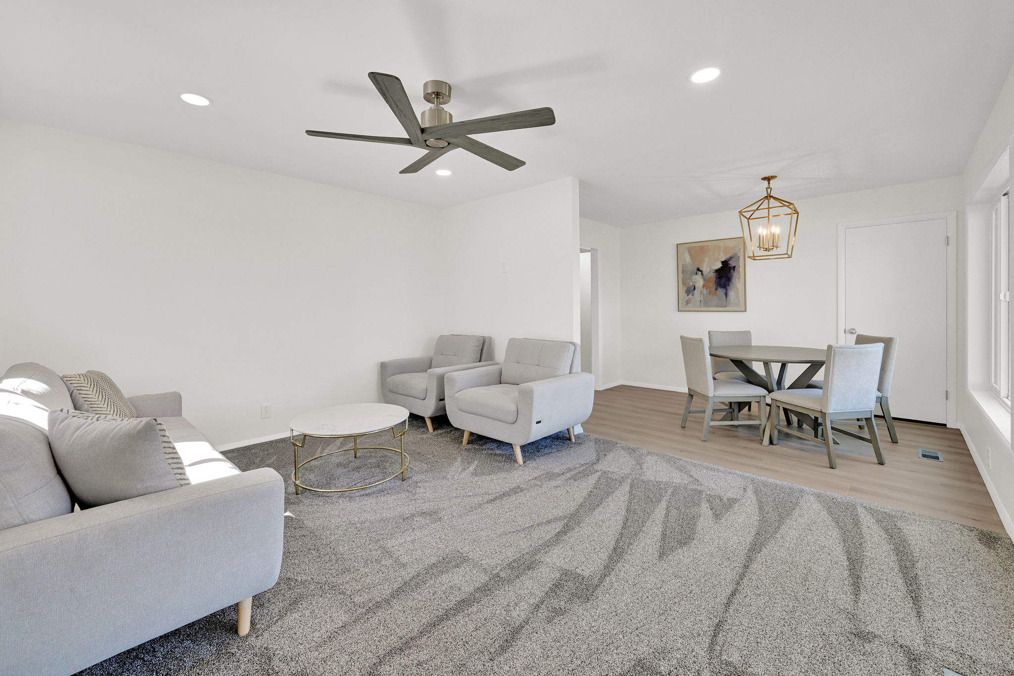 Open-concept living area with a ceiling fan, recessed lighting, and light wood-finish flooring