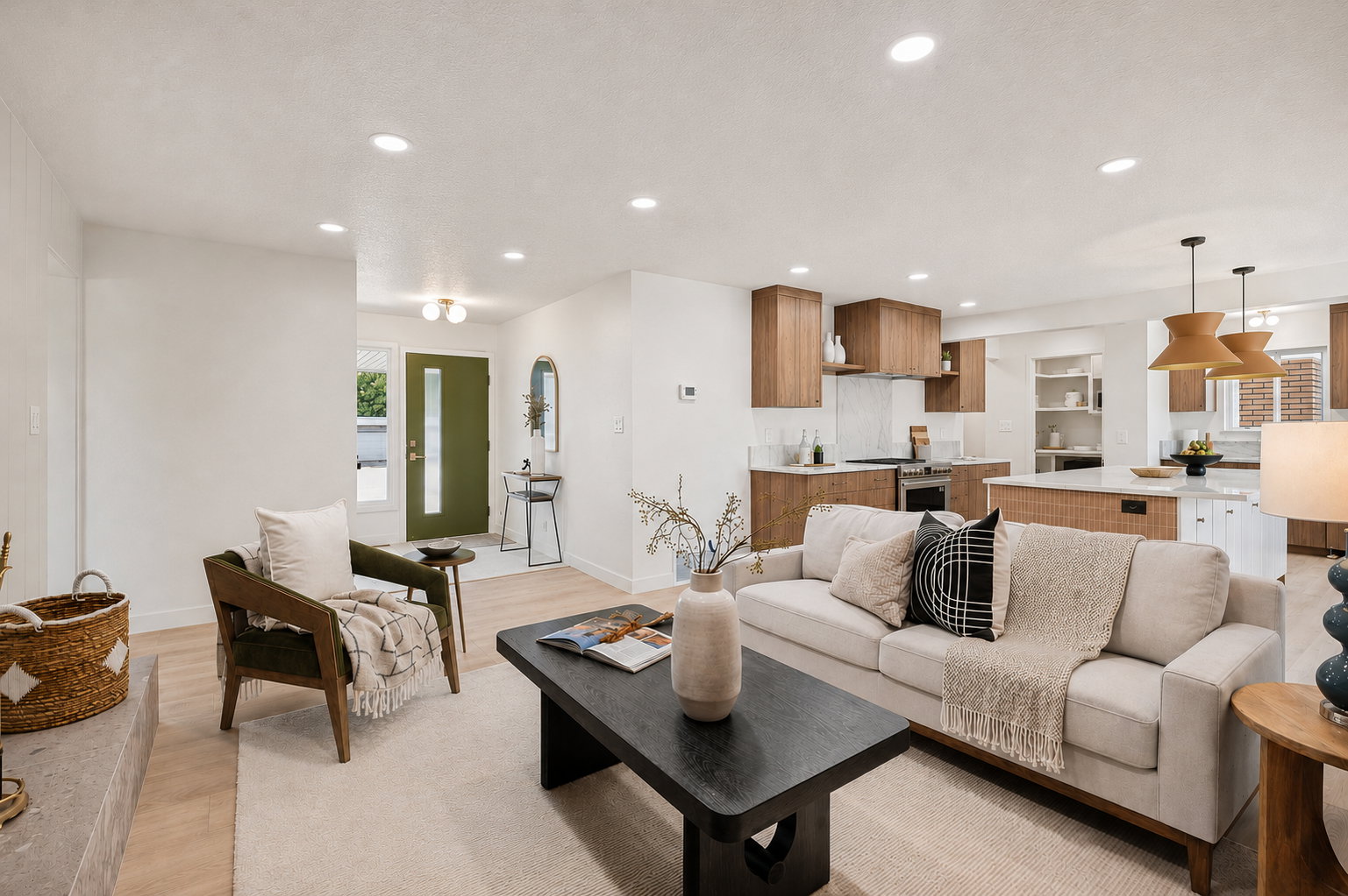 Open-concept living space featuring wood-finish flooring, recessed lighting, a modern kitchen with wood-tone cabinetry, and a central island with white countertops