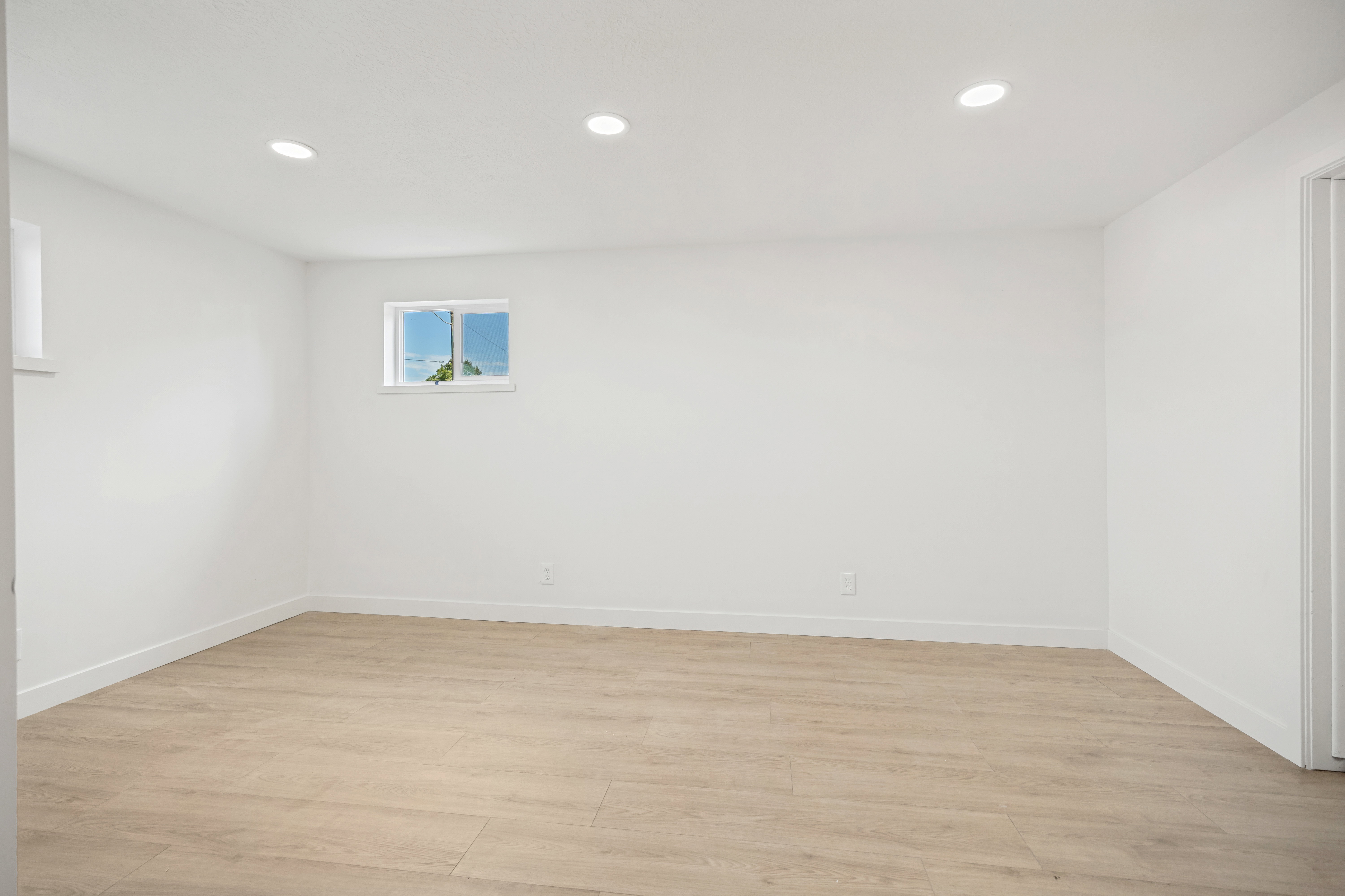 Bright room featuring wood-finish flooring and recessed ceiling lighting
