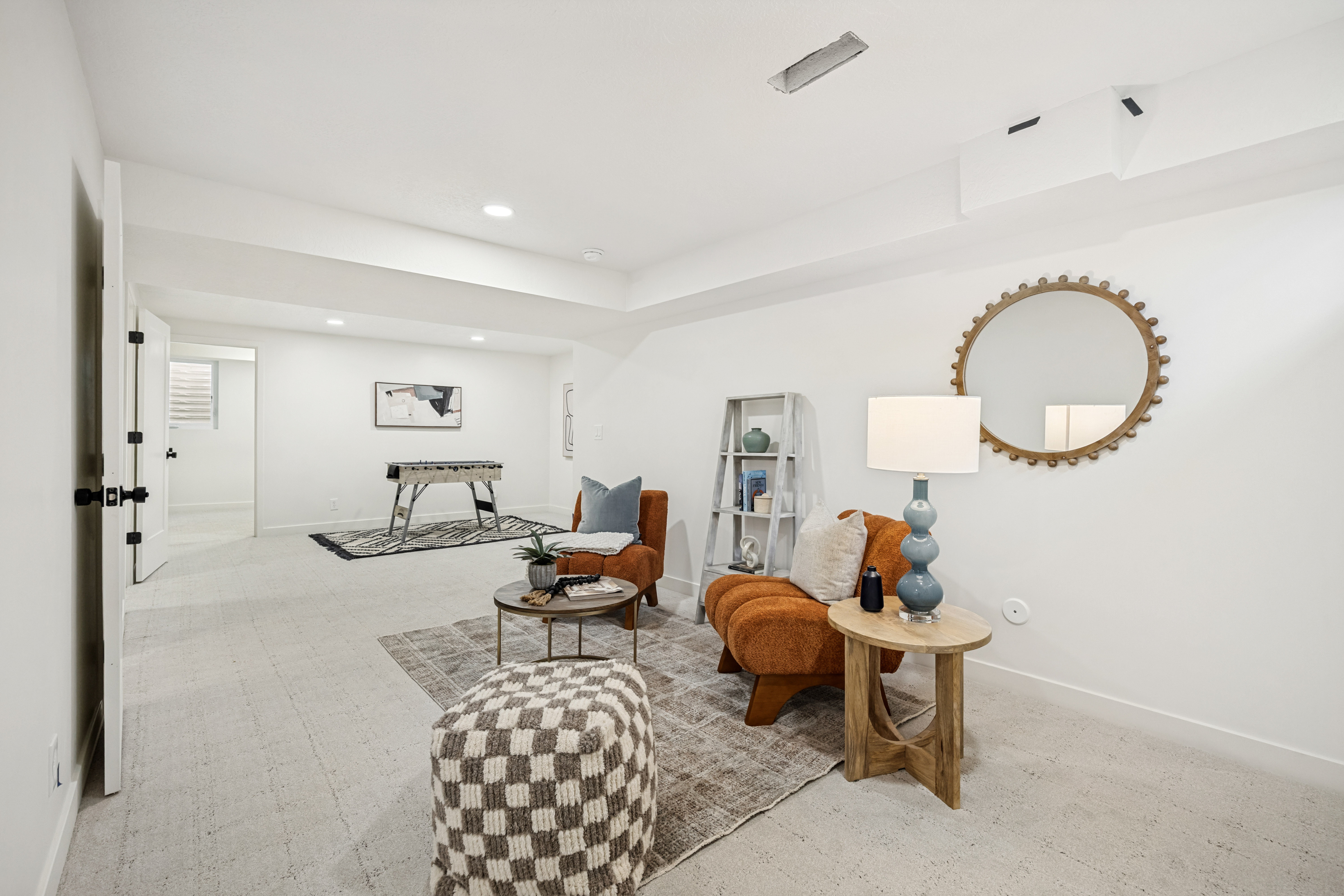 Spacious lower-level area featuring light-colored carpeting, recessed lighting, and white walls