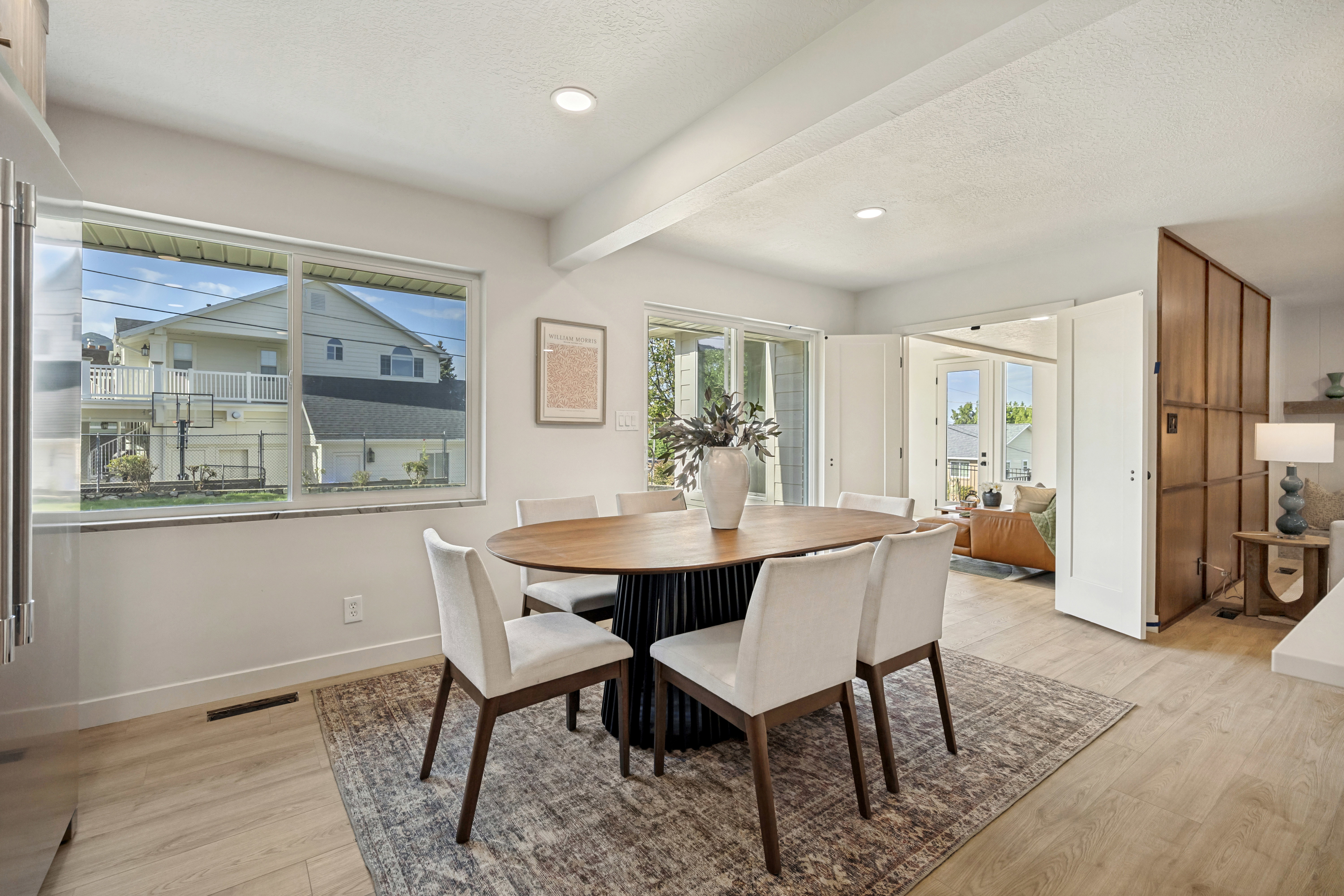 Spacious dining area featuring wood-finish flooring, recessed lighting, and a large window