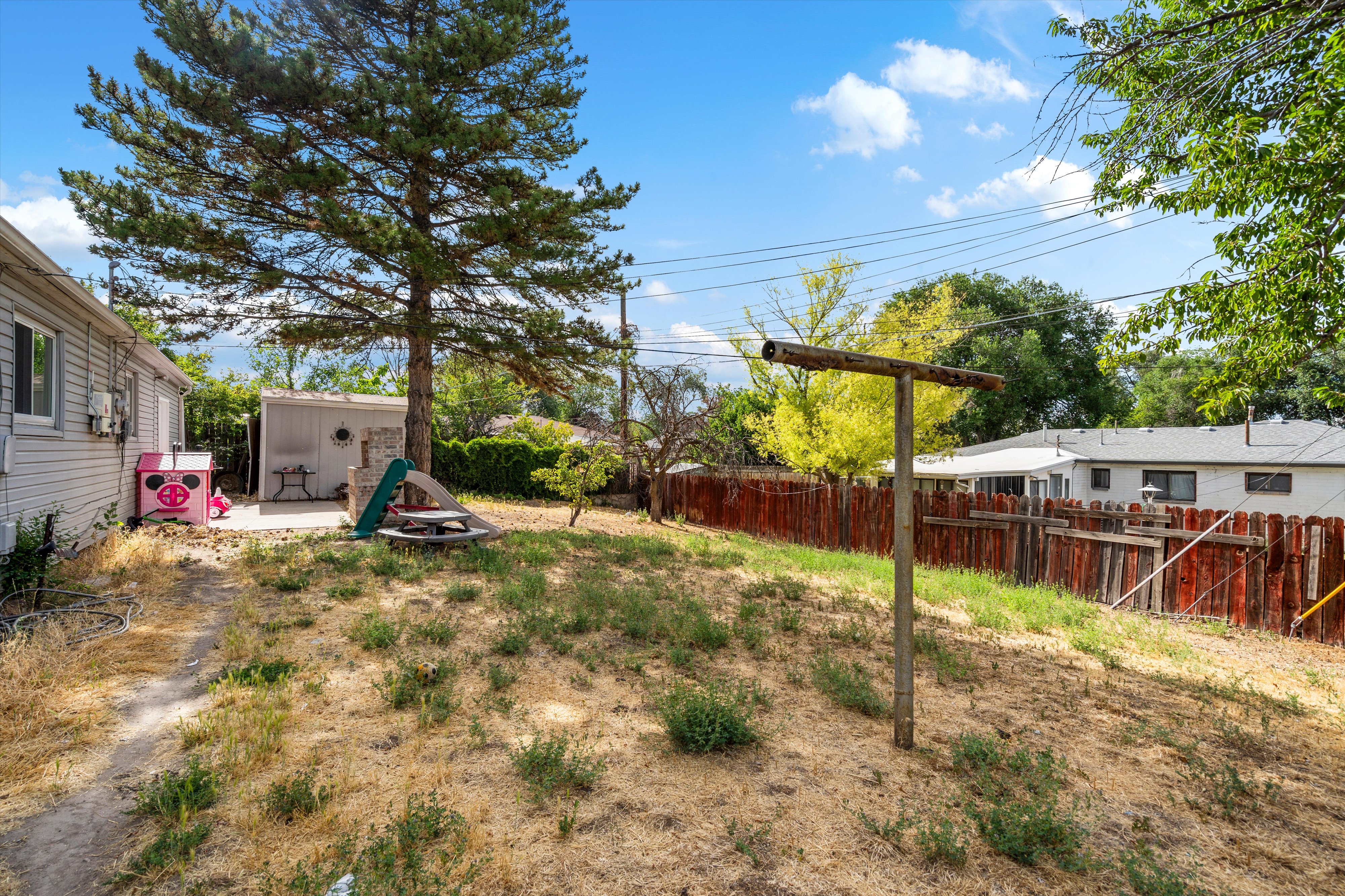Expansive outdoor space, paved patio, and a detached shed