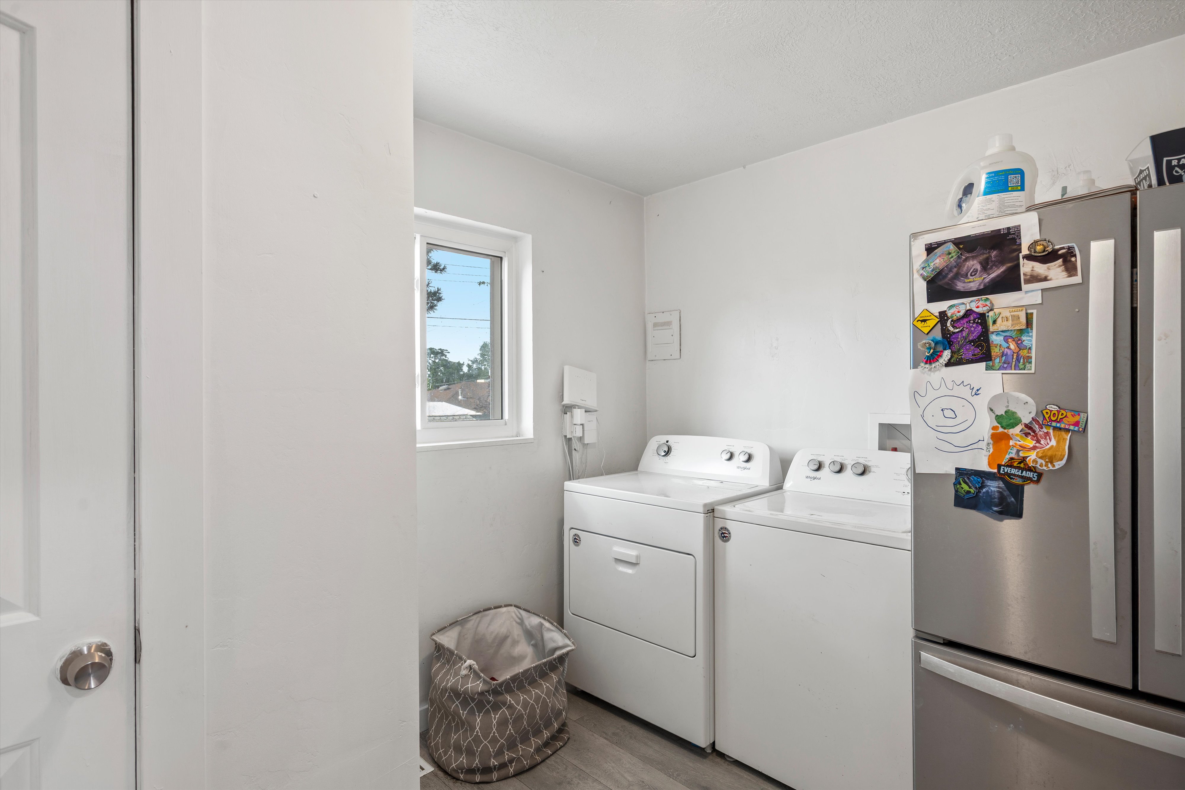 Dedicated laundry area with light wood-finish flooring