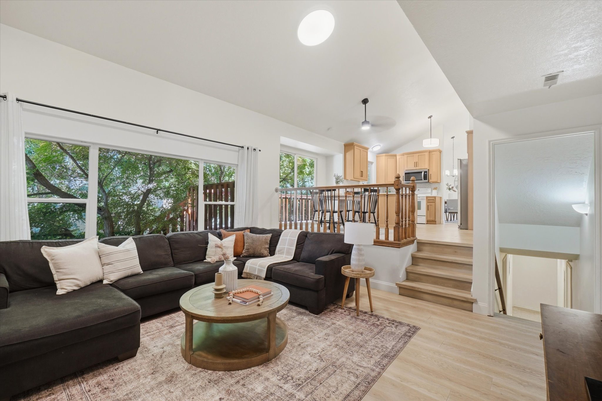 Living space with light wood-finish flooring and expansive windows