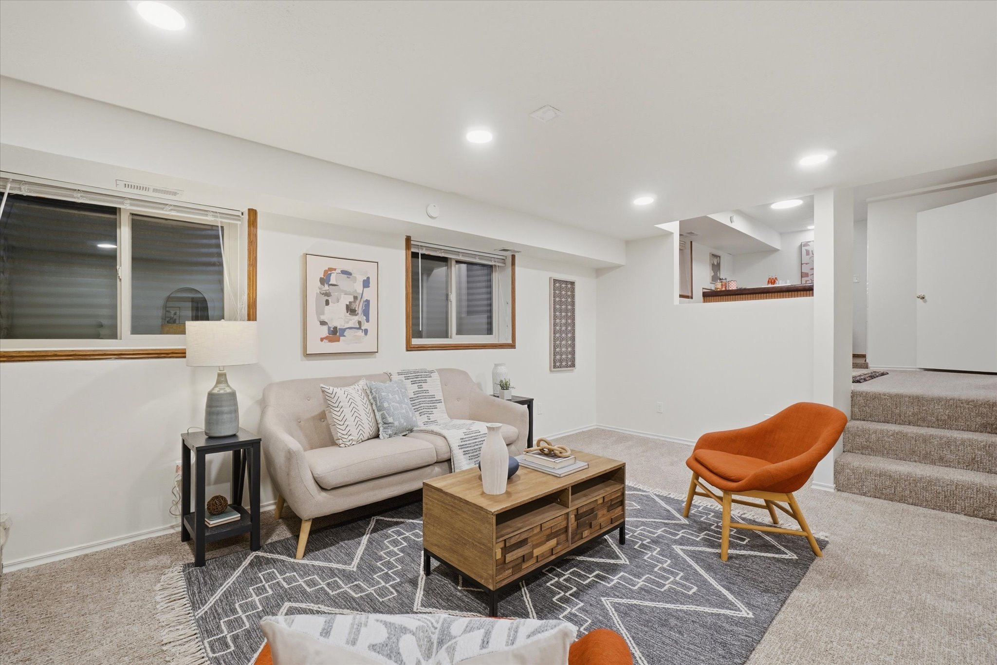 Carpeted living area featuring recessed lighting and multiple windows with wood trim