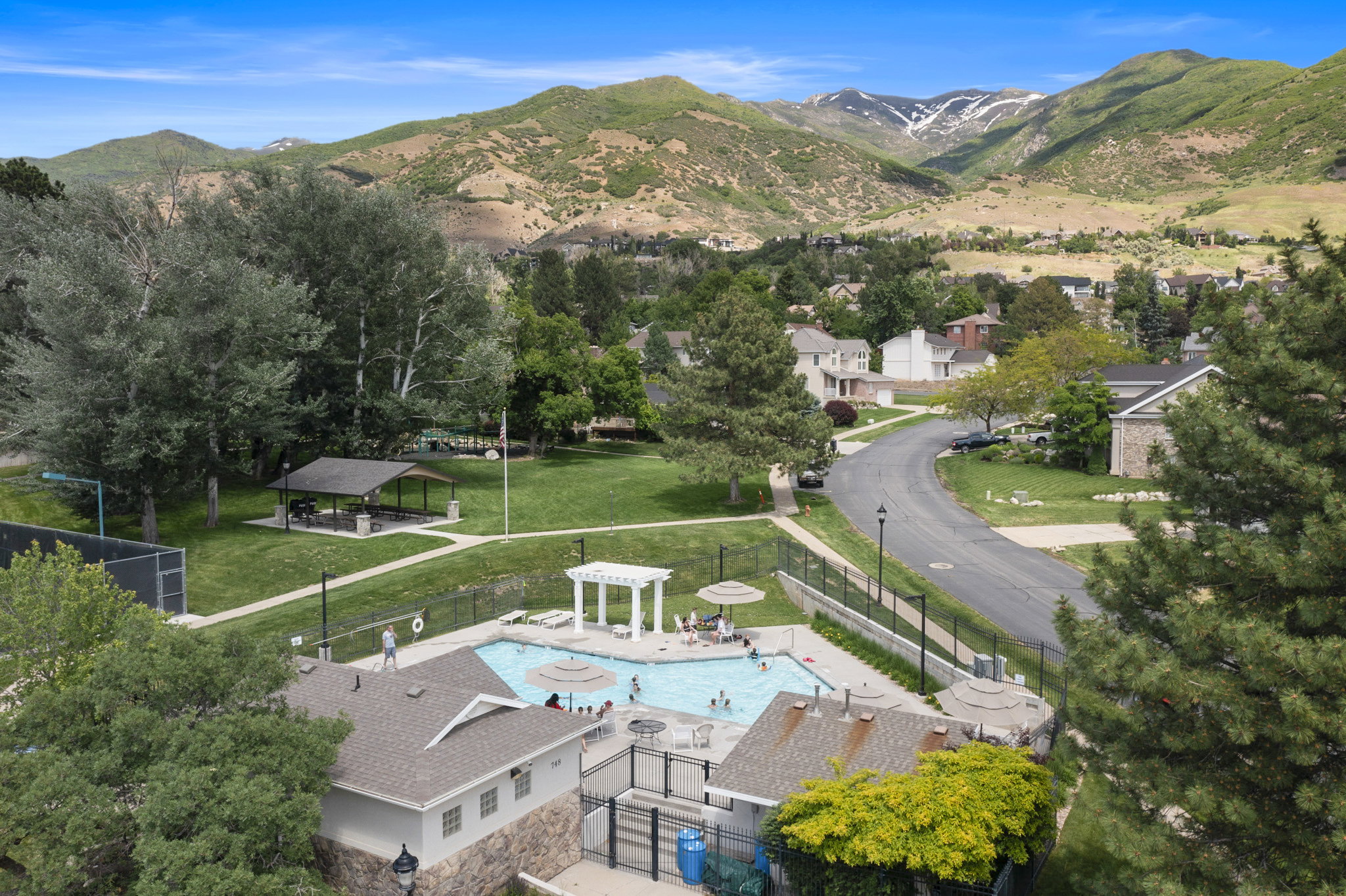 Community pool featuring a white pergola and surrounding lounge areas