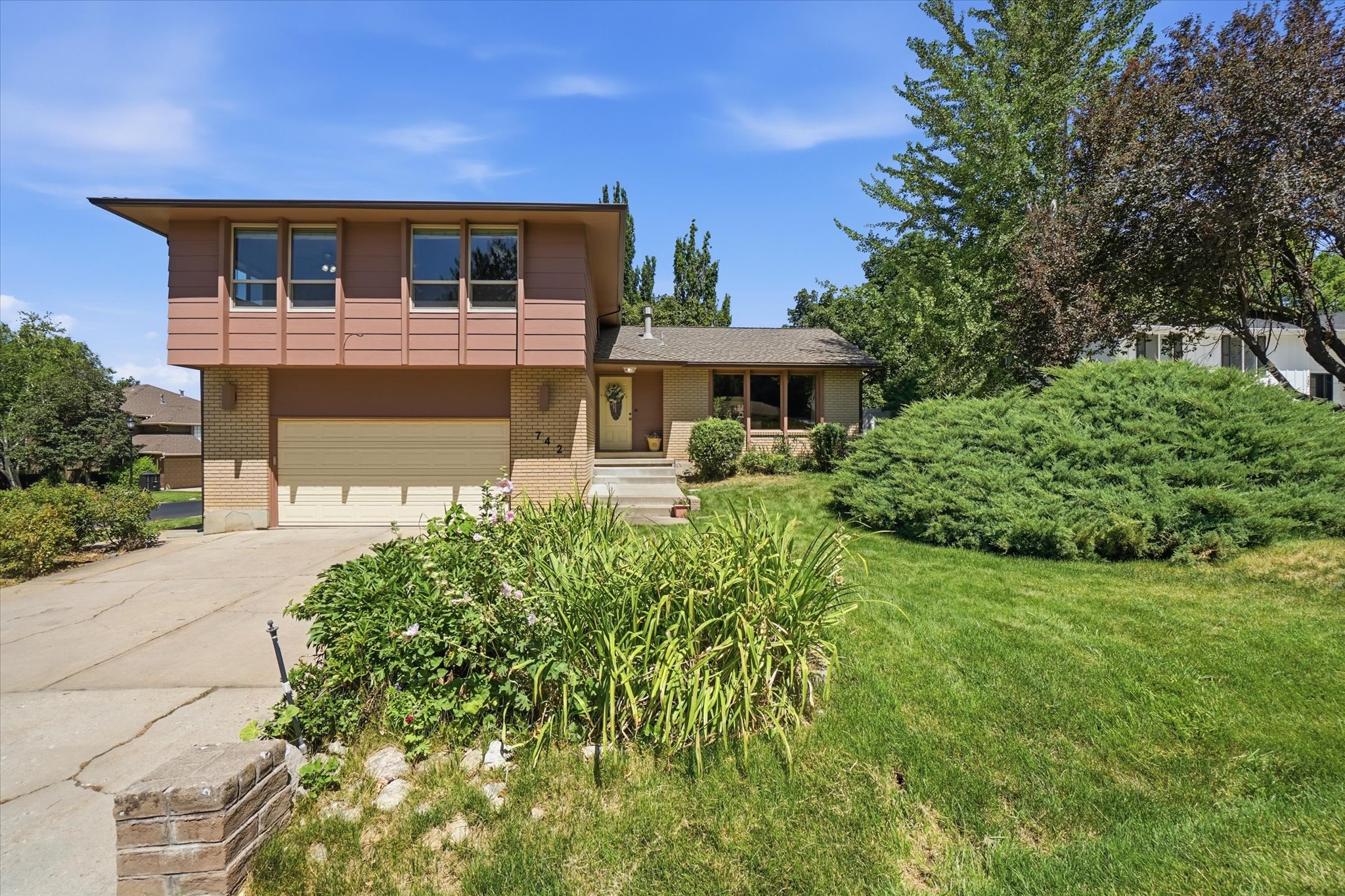 2 Story residence featuring a two-car garage, brick accents, and a covered entry