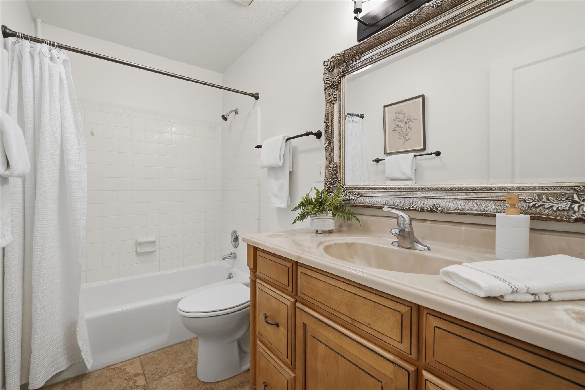 Bathroom featuring a light-toned vanity with an integrated sink and chrome faucet