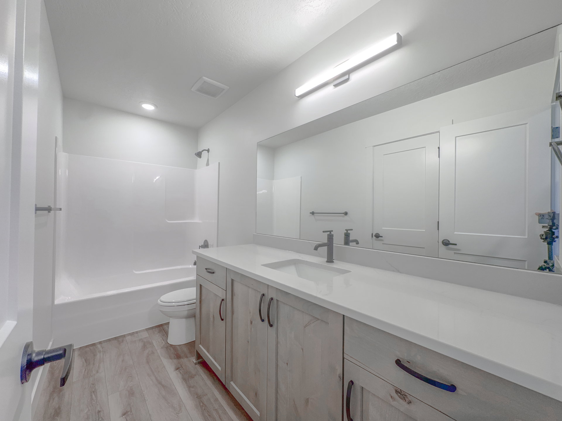 Full bathroom featuring a single vanity with wood-finish cabinetry and a white countertop