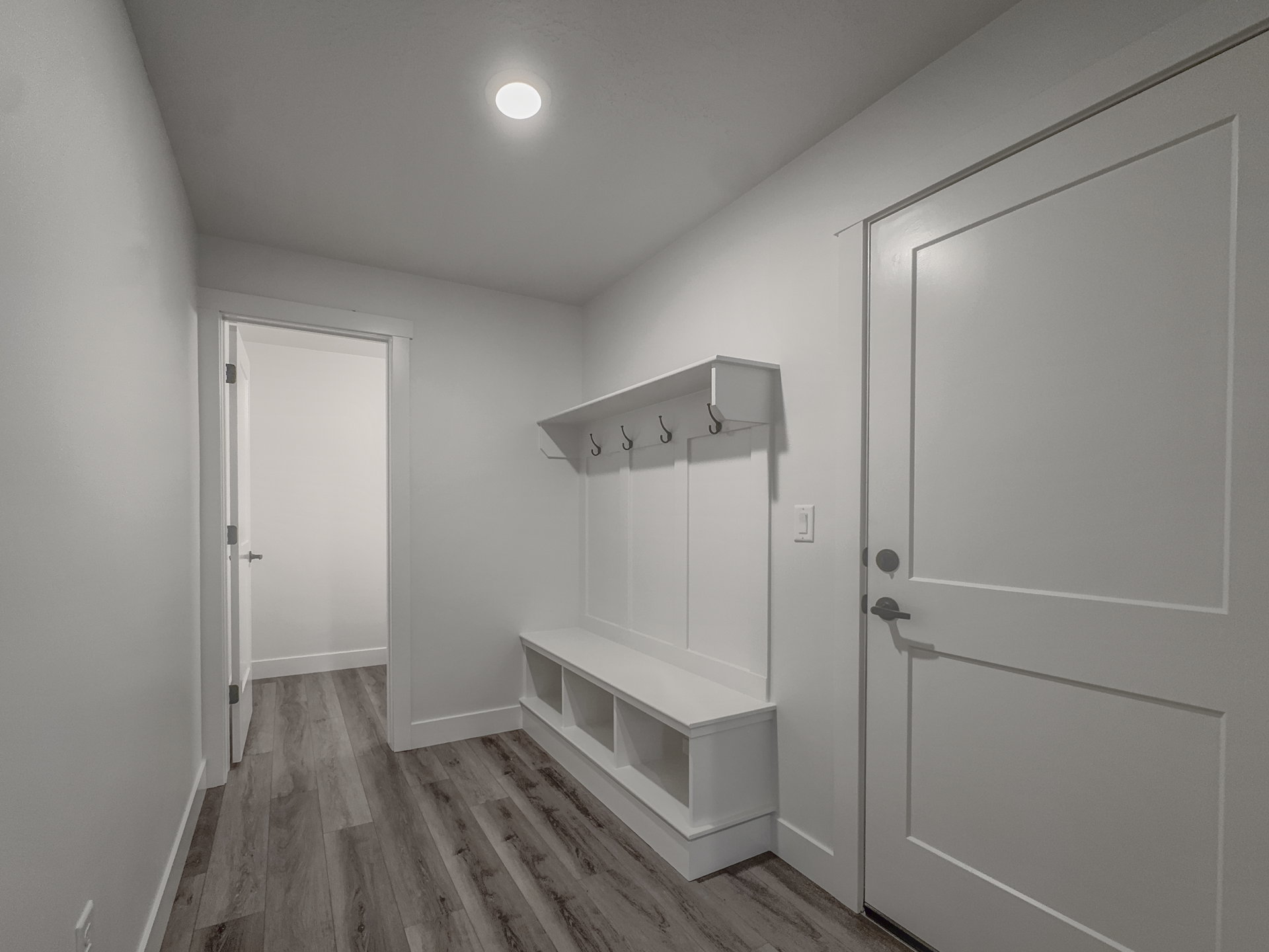 Entryway featuring wood-finish flooring, recessed lighting, and a built-in bench with storage cubbies and coat hooks