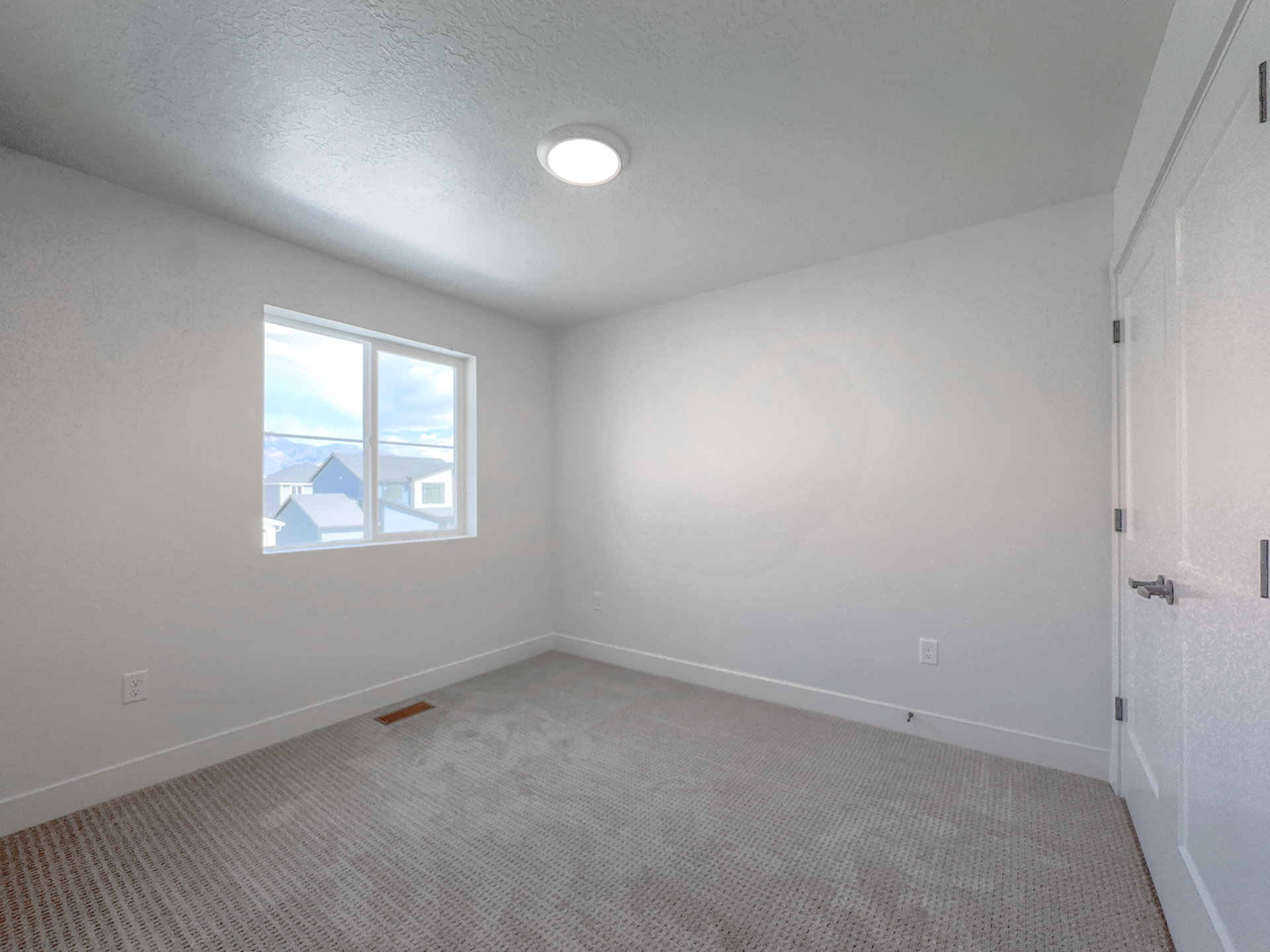 Bright room featuring a window with white trim, wall-to-wall carpeting, white baseboards, and a flush-mount ceiling light fixture